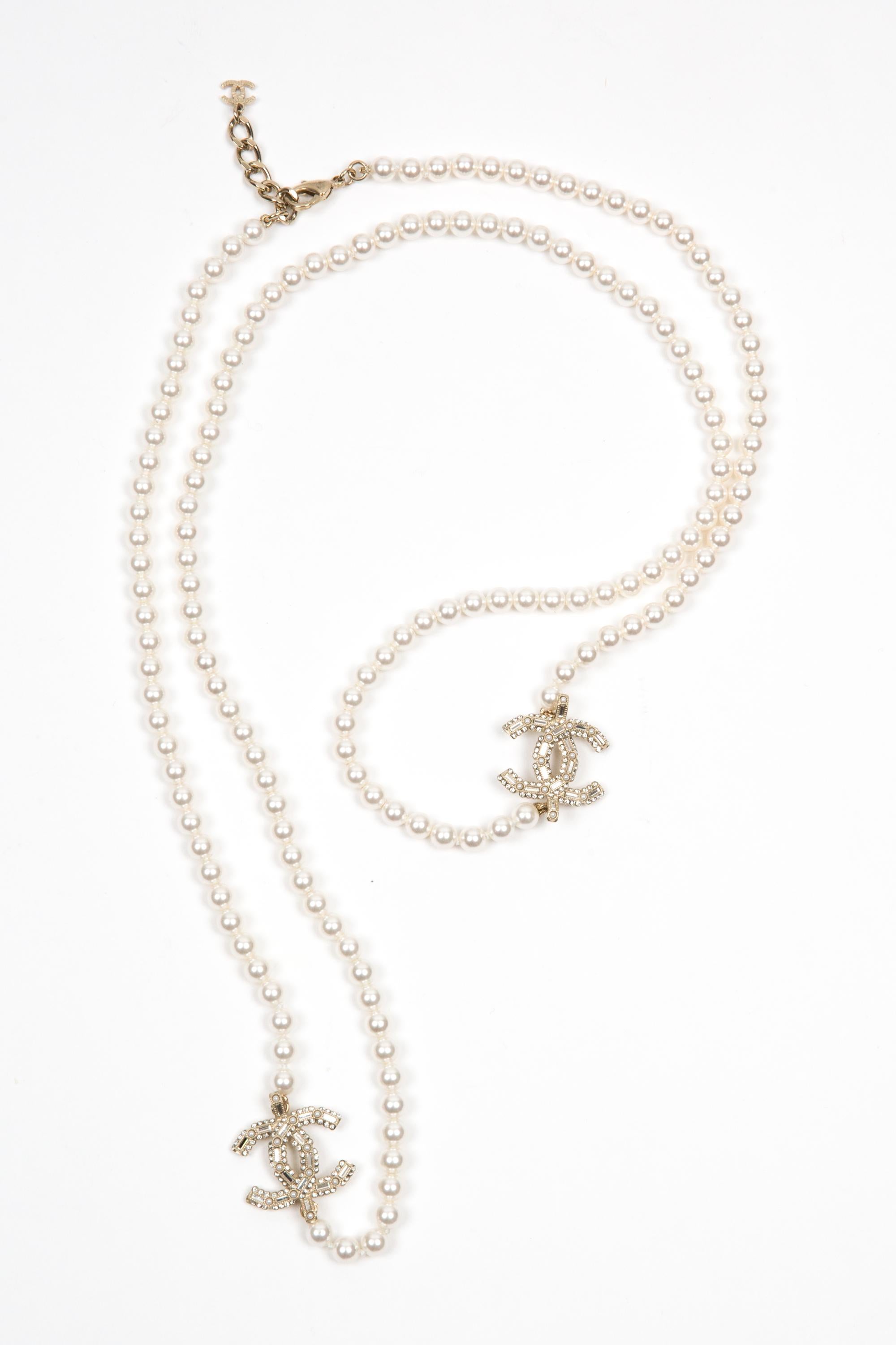 Chanel Ivory faux-pearls embellished long sautoir necklace featuring aux-pearls beads, white-gold-tone signature interlocking CC logo with embellished beads, a lobster claw fastening logo pitted on, an adjustable length with a free CC at chain end.