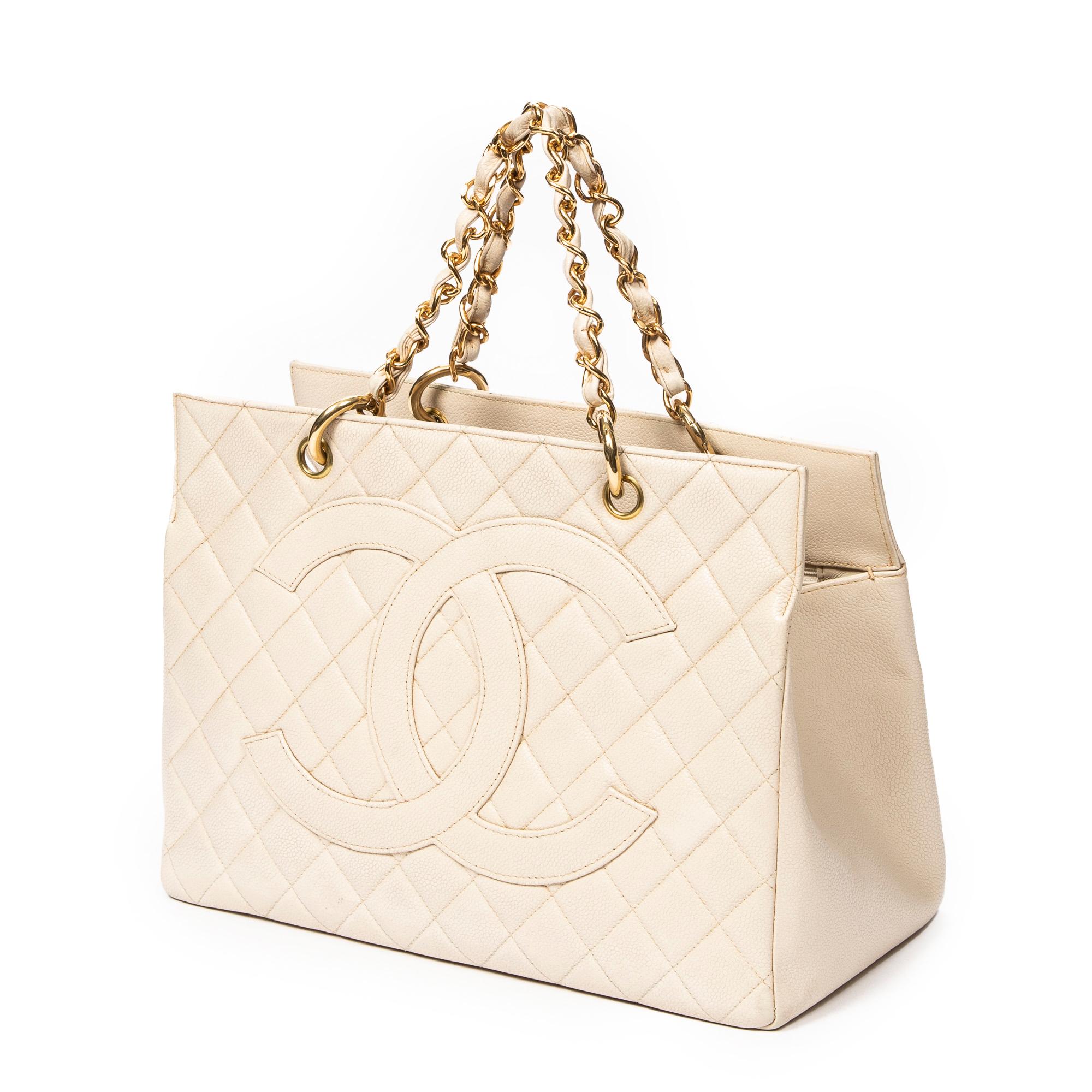Introducing the Chanel Ivory Grand Shopping Tote: an epitome of timeless elegance. Crafted from luxurious quilted caviar leather in a pristine ivory hue, this tote exudes sophistication. Adorned with gleaming gold hardware, it boasts a classic