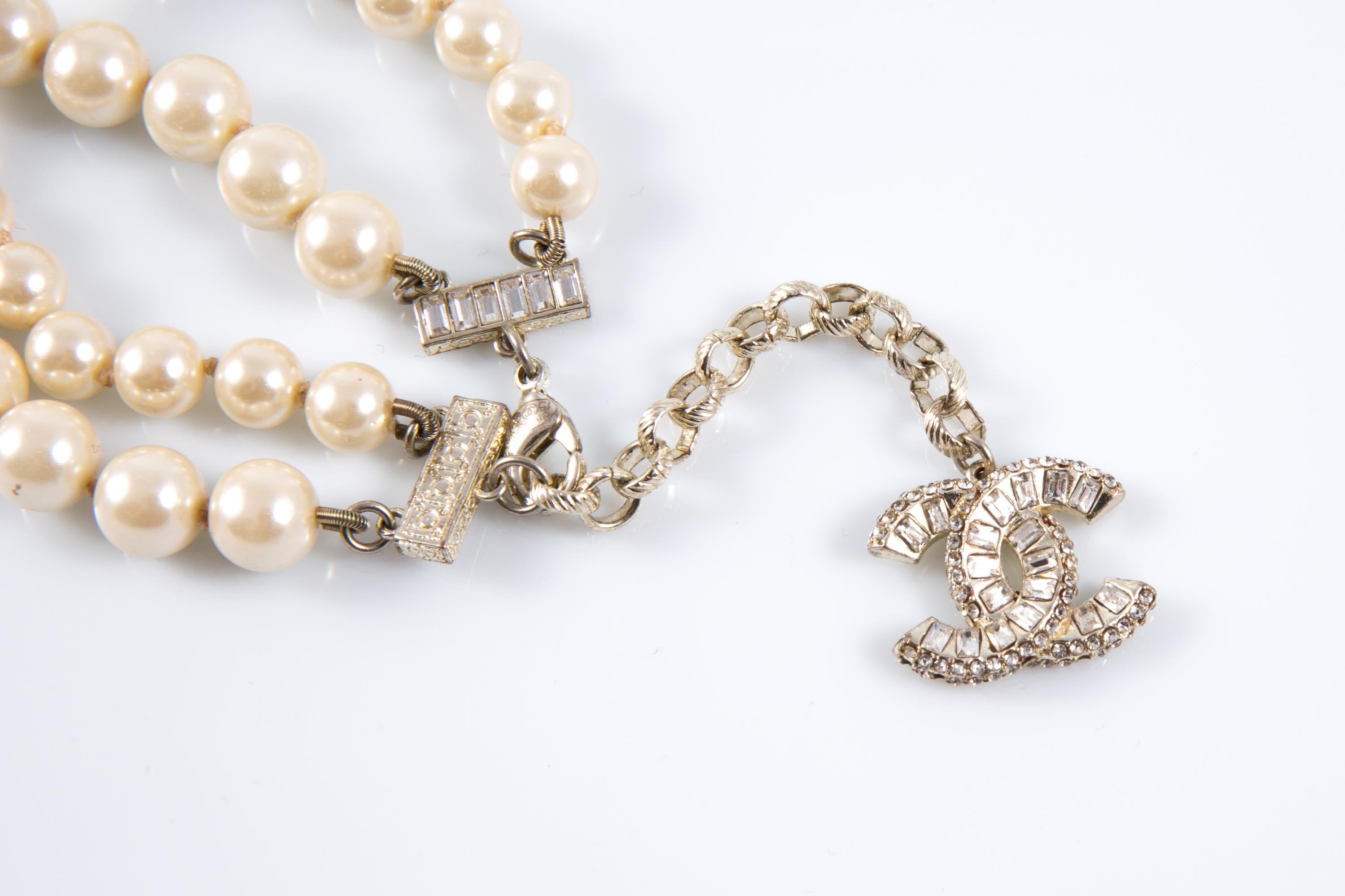 Bracciale Chanel avorio con perle finte grandi, charm impreziosito da strass e firma 