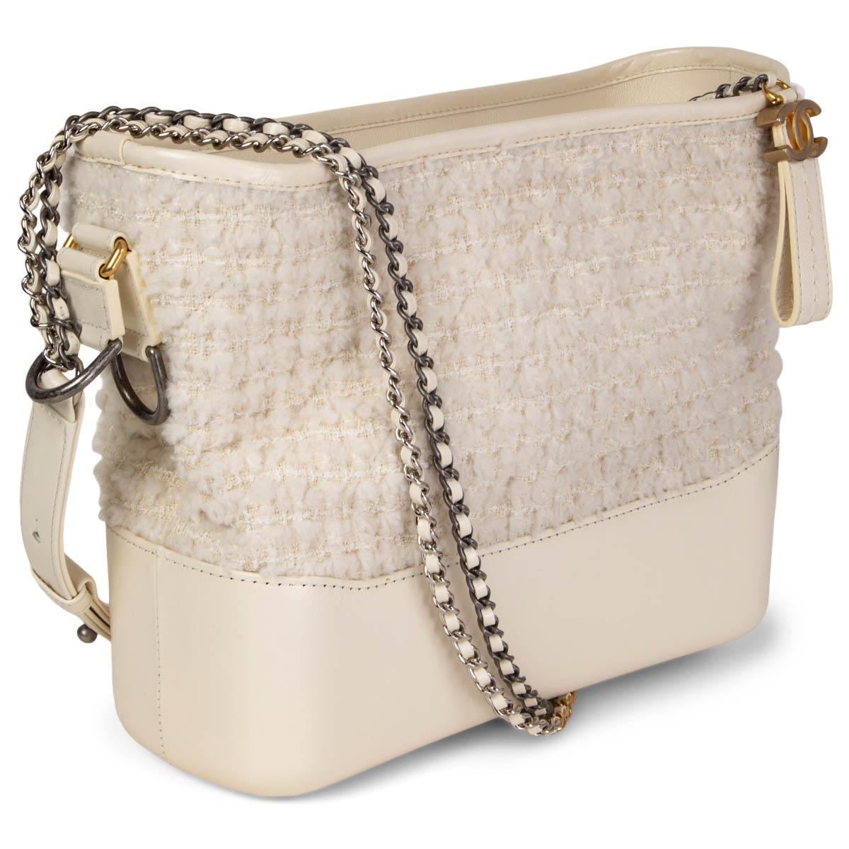 100% authentic Chanel Gabrielle Hobo bag in ivory bouclé tweed and calfskin. Doubel chain shoulder-strap in gold-tone, silver-tone & ruthenium-finish metal. Opens with a CC zipper on top and is lined in burgundy grosgrain fabric with one zipper