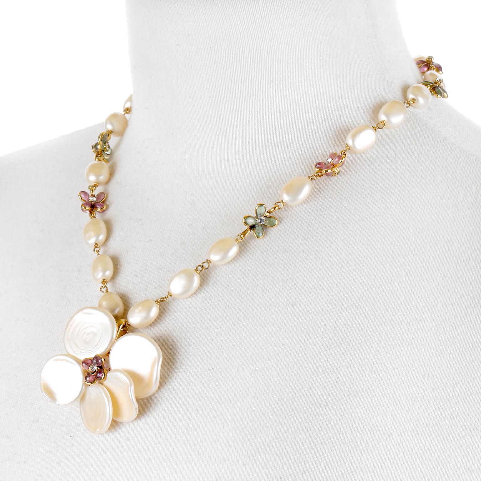This authentic Chanel Pearl Camellia Necklace is in excellent condition from the Spring 1999 collection.  Large faux pearls are strung together with gold tone chain and are separated by dainty enamel flowers in dusky pink and green. A large mother