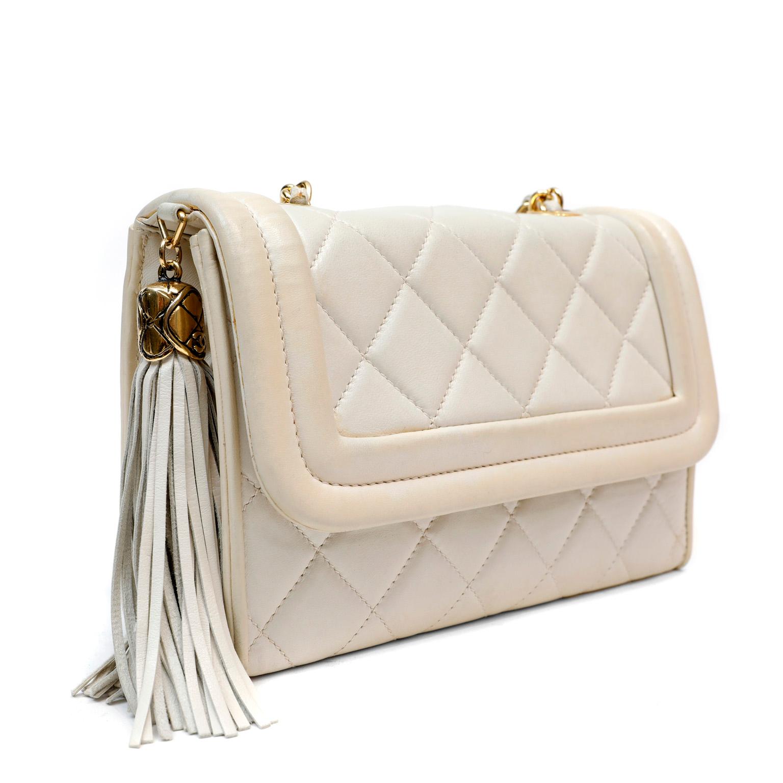 This authentic Chanel Ivory Quilted Lambskin Vintage Flap Bag is in good previously owned condition.  Late 80’s- early 90’s collectible.  Ivory lambskin is quilted in signature Chanel diamond pattern.  Reinforced welted edge frames the front flap. 