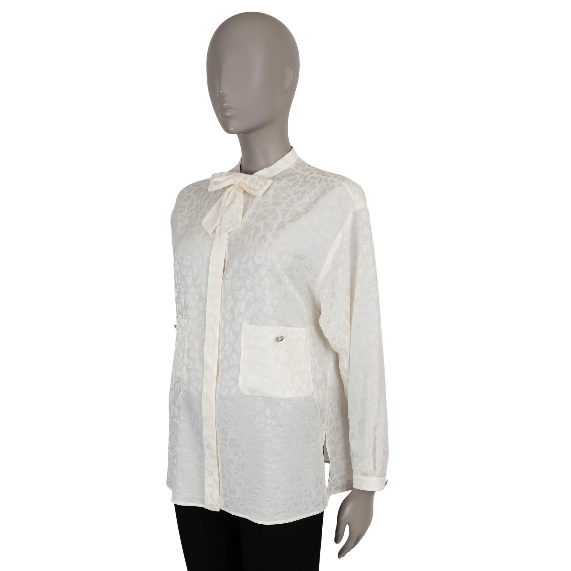 This 100% authentic Chanel leopard and cc logo jacquard blouse is crafted from luxurious ecru silk (100%). The design features two silver-tone logo buttoned patch pockets at the front, a concealed button line, two cuff buttons and an elegant bow