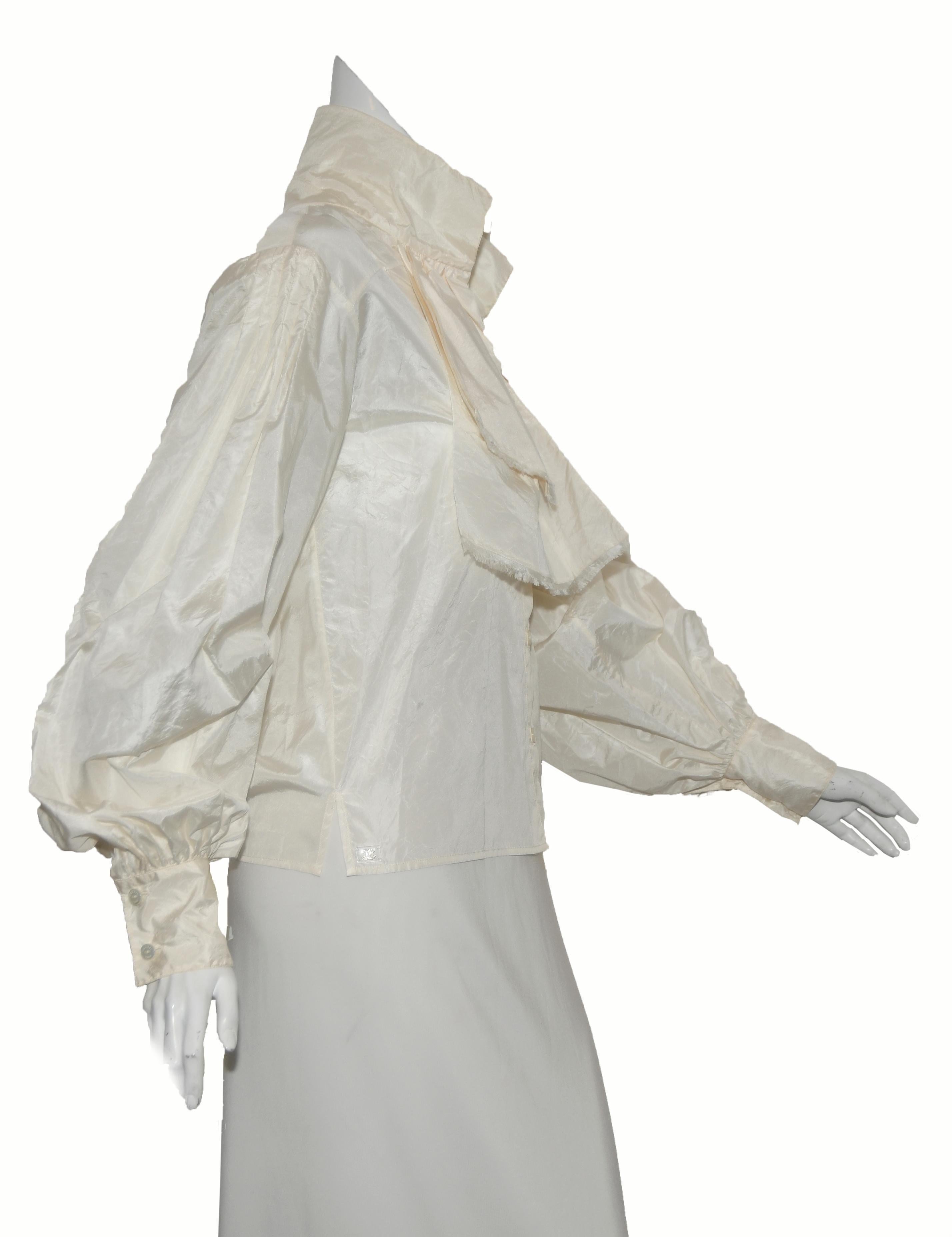 Chanel Ivory silk shantung long sleeve blouse contains two old fashion cravats to be tied at the neck under the shirt collar.  Five ivory colored buttons are used for closure at front and two additional buttons on each cuff.  The long sleeves are