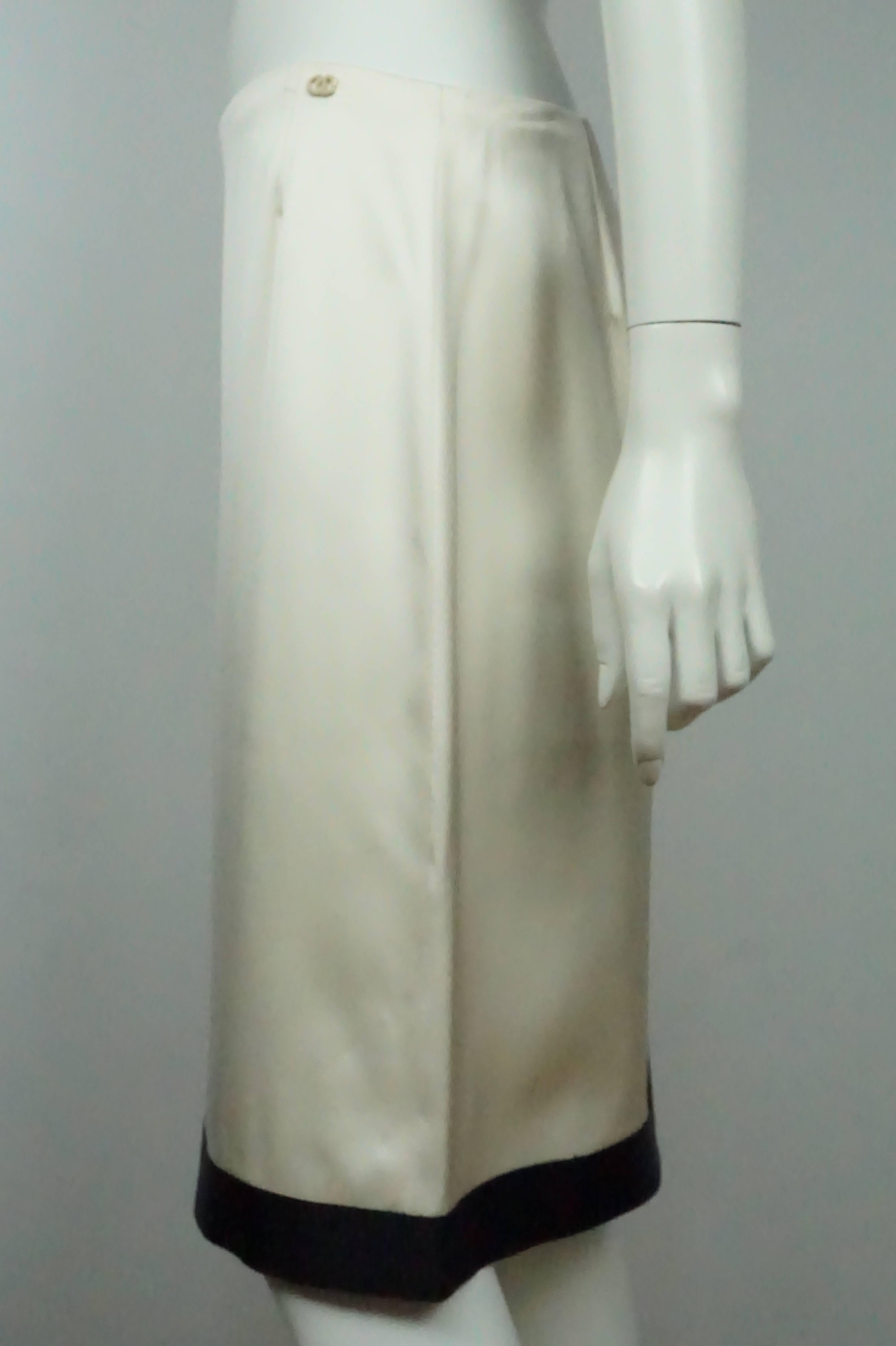 Chanel Falda de Seda Marfil con Ribetes Negros - Mediana  Esta elegante pieza de Chanel está en excelentes condiciones. Es una falda recta muy sencilla, totalmente de seda. Hay un ribete negro en la parte inferior y también hay un logotipo CC perla
