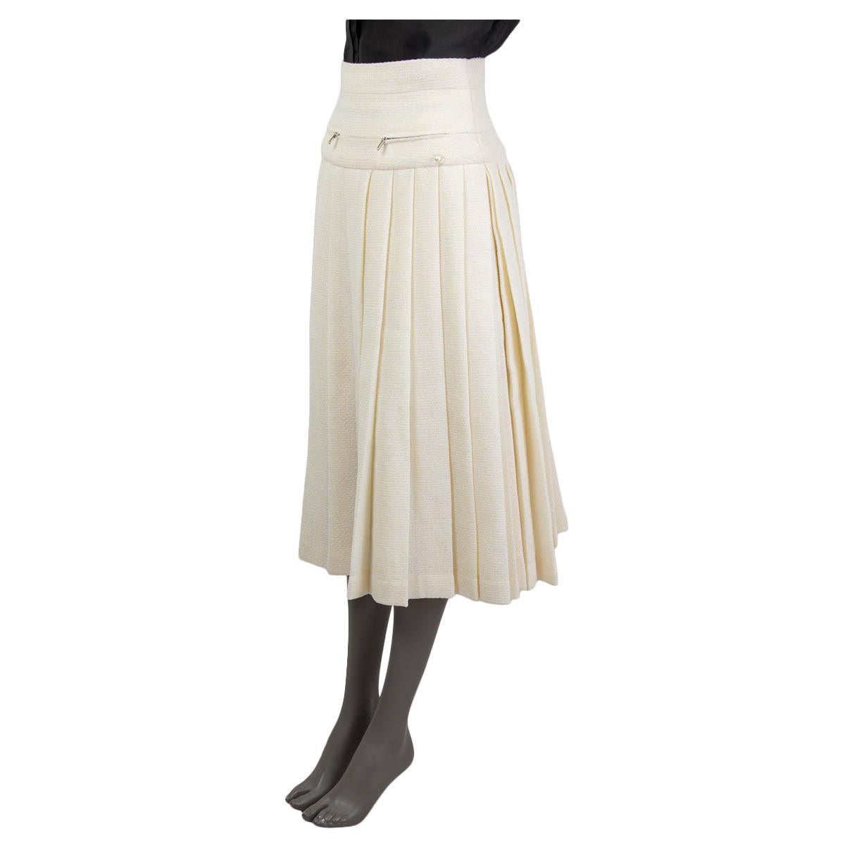 100% authentic Chanel pleated lurex high-waist midi skirt in ivory polyester (49%), wool (43%) and polyamide (8%) mixed with lilac metallic lurex threads. Fall/winter 2017 collection. Skirt has two faux zipper pockets at front and two slits on the
