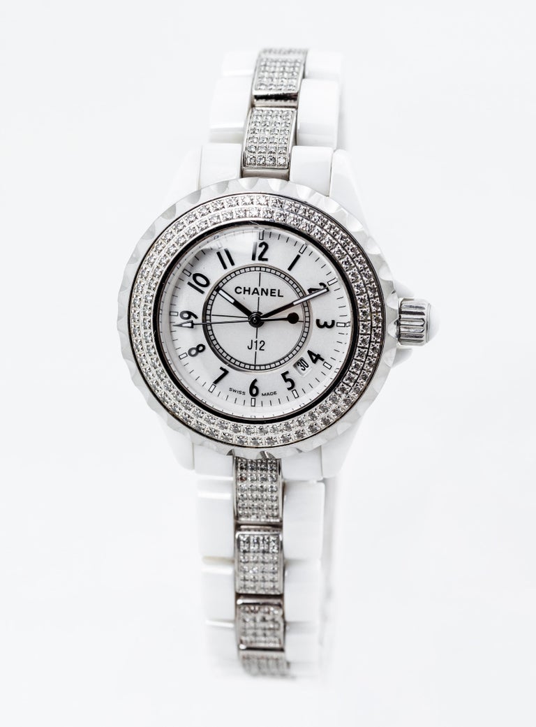 Chanel J12 White ceramic case with a white ceramic bracelet. Unidirectional rotating stainless steel bezel with a white ceramic inlay. Mother of pearl dial with silver-tone hands and diamonds hour markers. Arabic numerals mark the 3, 6, 9 and 12