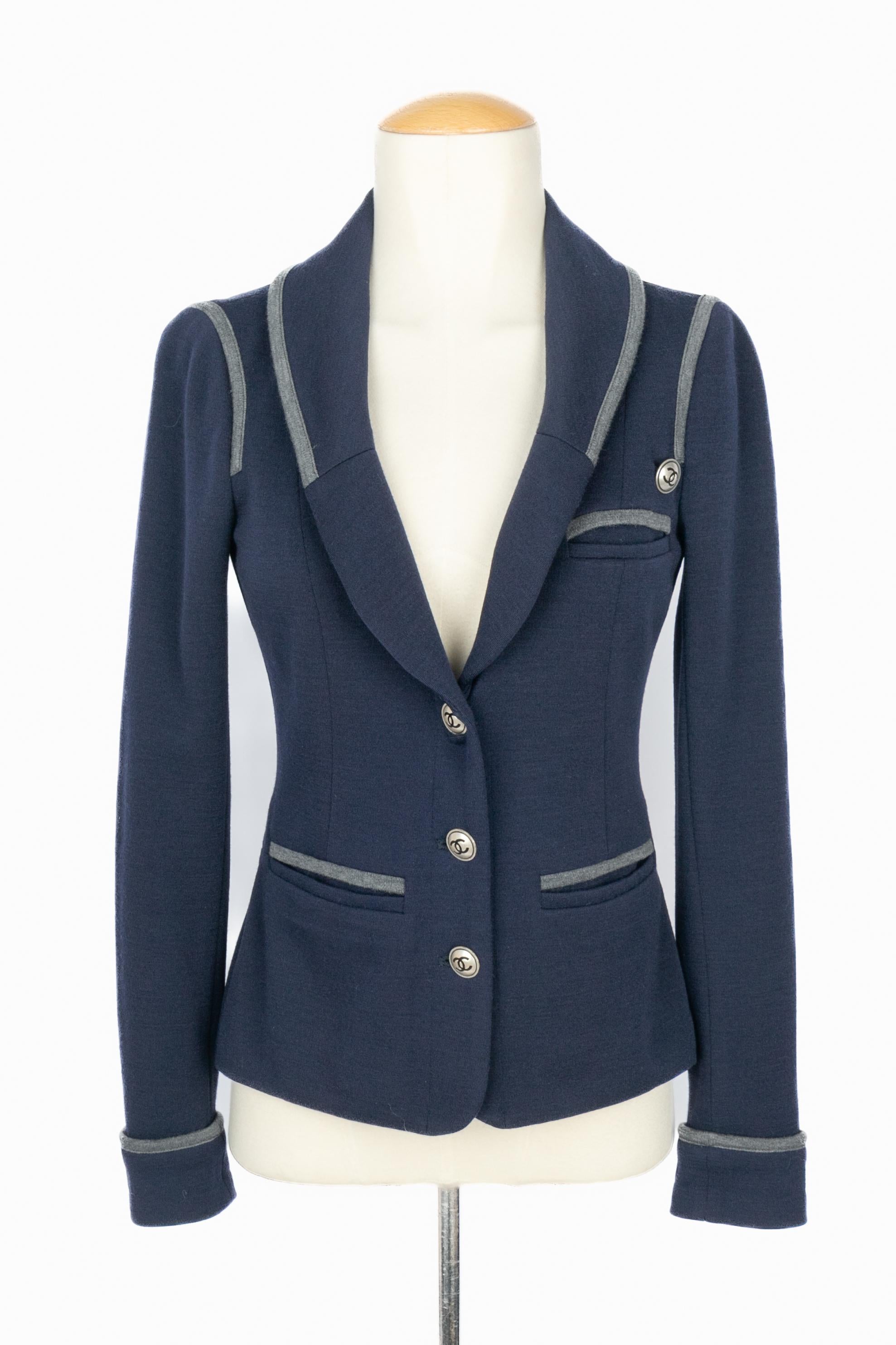Chanel - (Made in France) Giacca in jersey blu navy ricamata con jersey grigio, bottoni in metallo argentato verniciati di nero. Indicata la taglia 34FR. Una collezione del 2010 circa sotto la direzione artistica di Karl