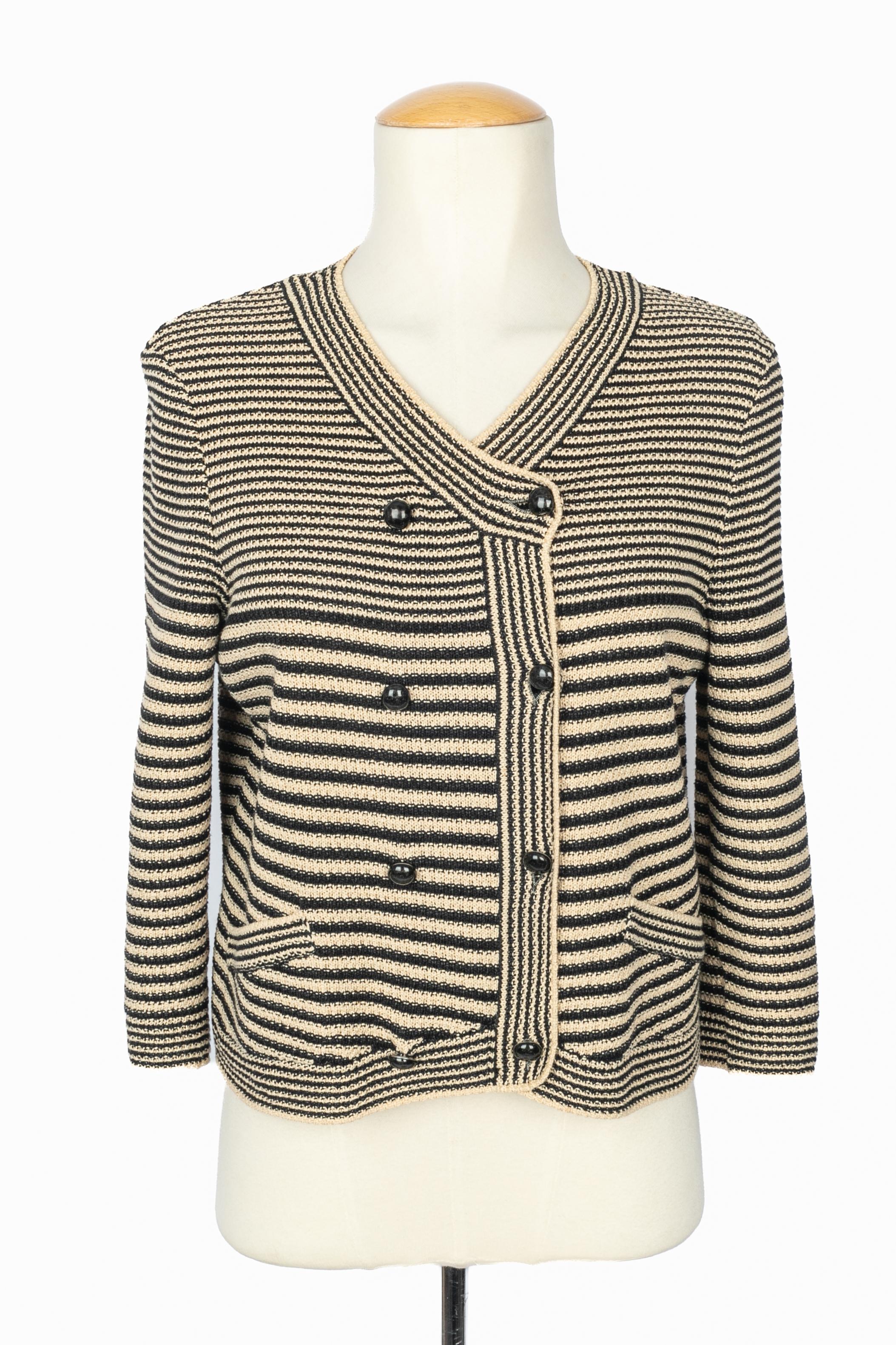Chanel - Giacca corta in maglia a righe nere e beige. Bottone in metallo argentato e smalto. Non è indicata la taglia, si adatta a una taglia francese 36/38/40. Collezione Resort 2015 sotto la direzione artistica di Karl
