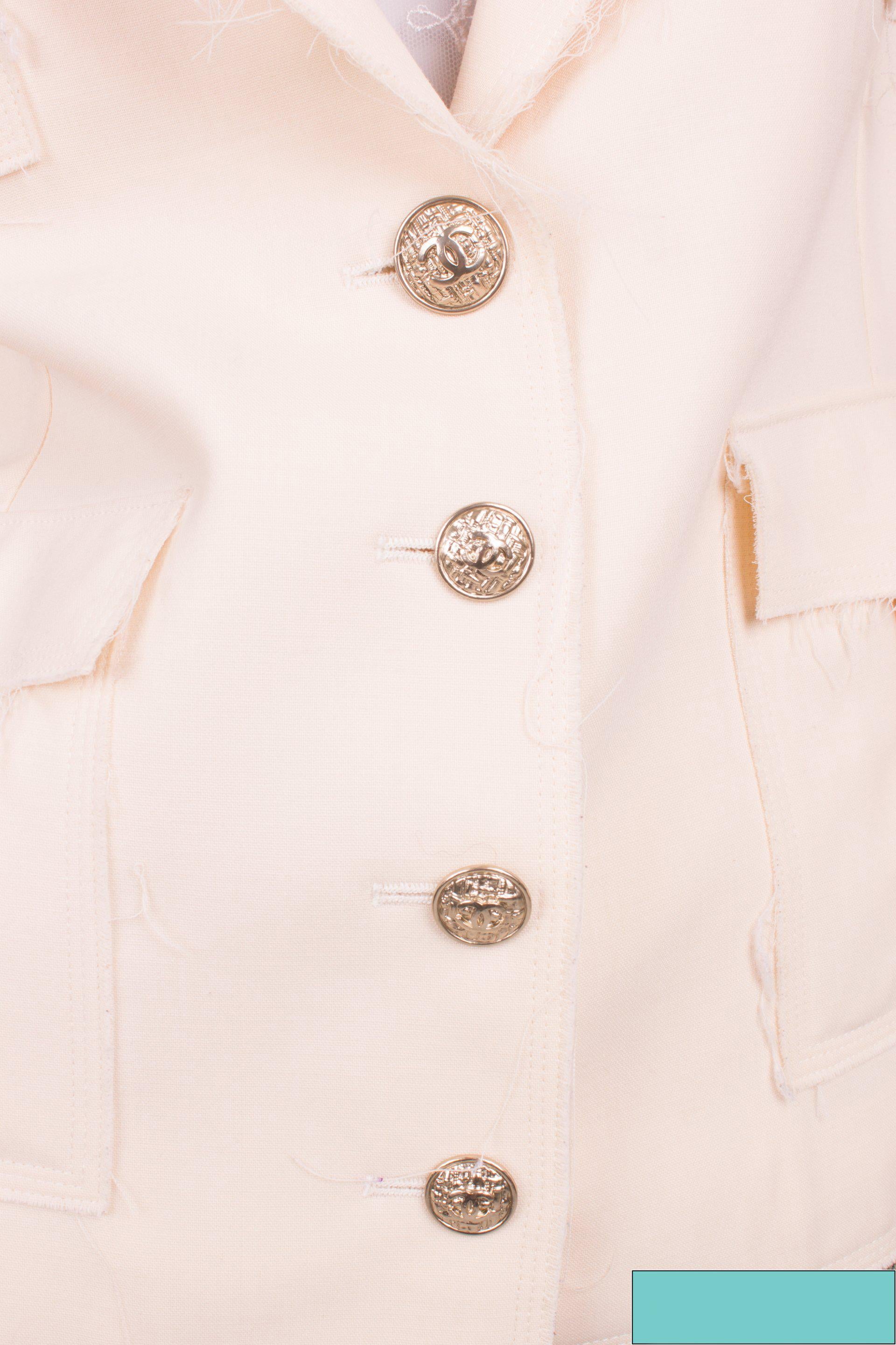 

Stirdy jacket by Chanel made of beige wool and silver buttons.

This jacket has large lapels and four-button closure at the front. The upper button is one size larger than the three underneath. An interlocking CC logo in the center. At the end of