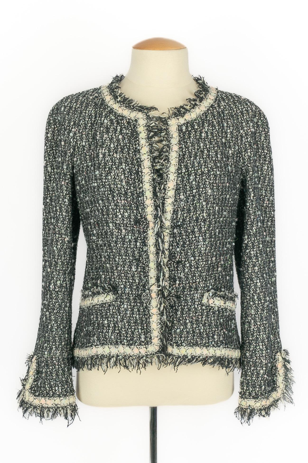 CHANEL - (Fabriqué en France) Veste en tweed gris et blanc avec une doublure en soie noire. Taille 38FR. Collectional automne-hiver 2005 sous la direction artistique de Karl Lagerfeld.

Condit :
Très bon état.

Dimensions :
Largeur des épaules : 43