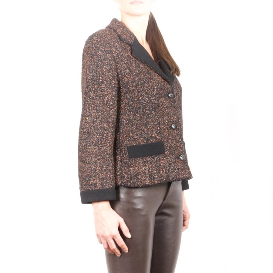 CHANEL jacket in brown tweed and black wool. It has 2 front pockets and closes with 3 transparent resin buttons with CC logo in black metal.
The lining is in black silk with Camélia, CC and the Chanel signature.
In very good condition.
Flat