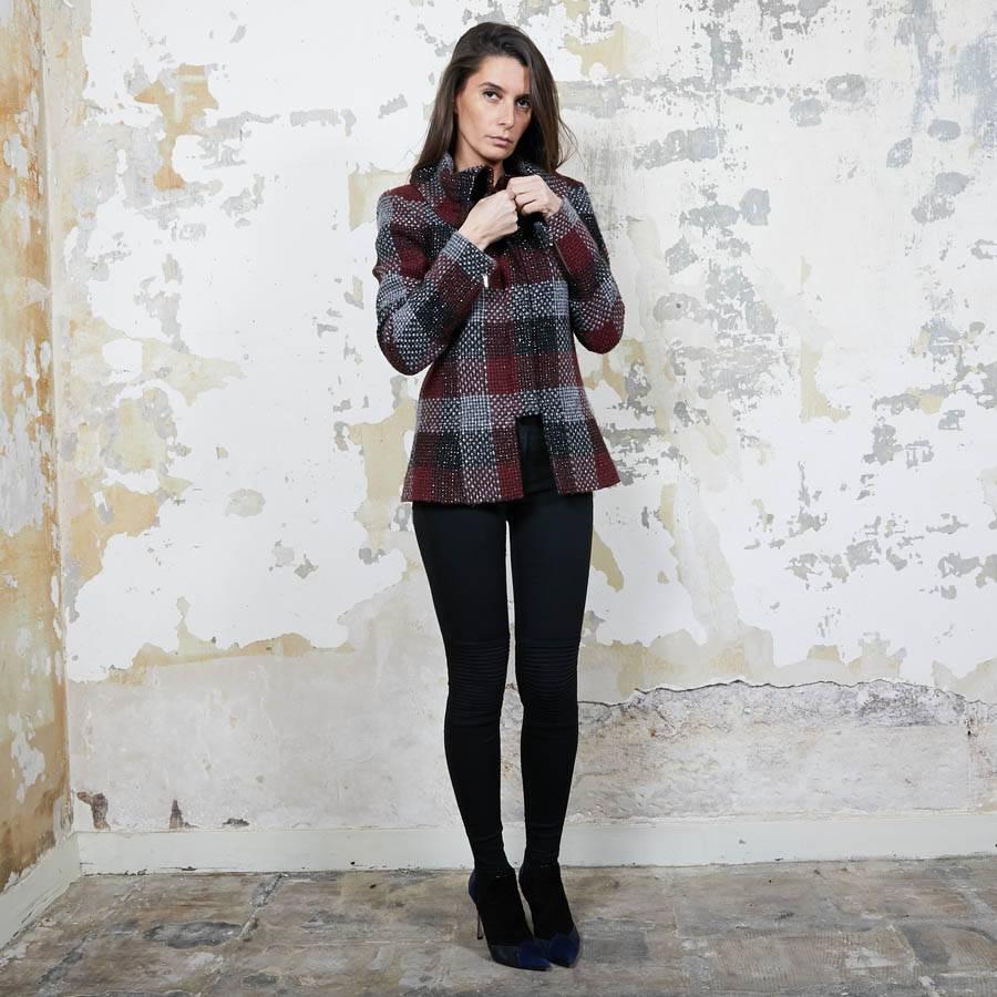 Splendida giacca Chanel in tweed a quadri rossi, argento e neri. Si chiude con dei bottoni neri contrassegnati da una pasta. La fodera è in seta monogramma bordeaux.

Condizioni di zecca (proviene da vendite private). Colletto a camino con 3 bottoni