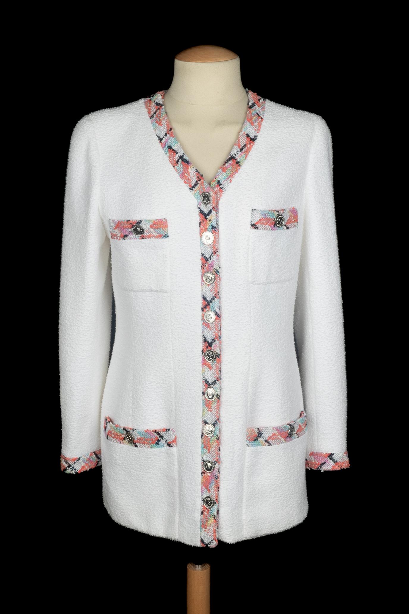 CHANEL - (Made in France) Weiße Tweedjacke mit mehrfarbigen Borten und silbernen Metallknöpfen mit dem Bildnis von Coco Chanel. Keine Größenangabe, es passt eine 36FR/38FR. Spring-Summer Collection 1996 unter der künstlerischen Leitung von Karl