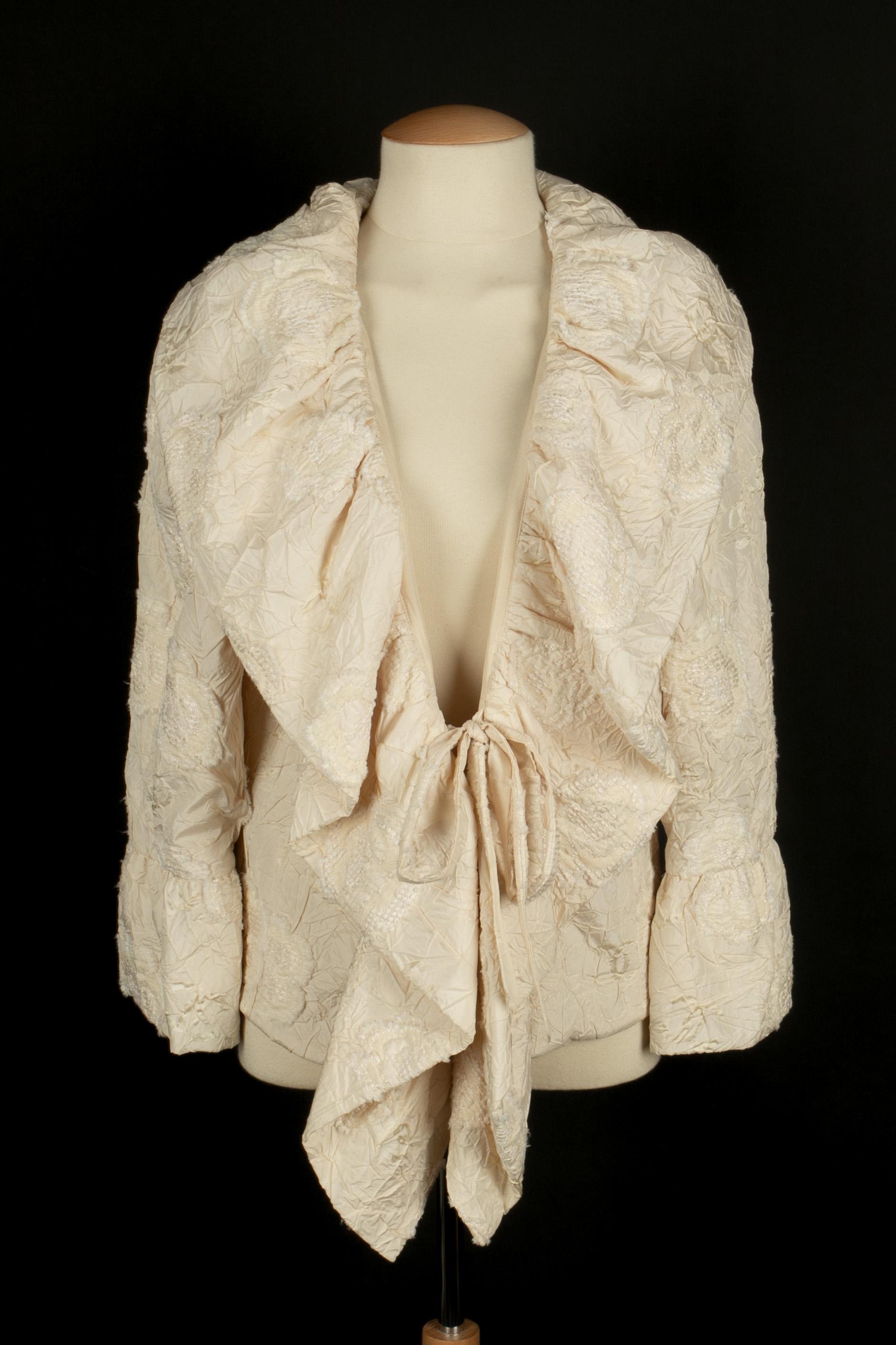 CHANEL - (Fabricado en Francia) Chaqueta de seda con efecto arrugado, adornada con camelias de tweed de color hueso. Talla 42FR indicada. Colección Primavera-Verano 2006 bajo la dirección artística de Karl Lagerfeld.

Estado:
Muy buen