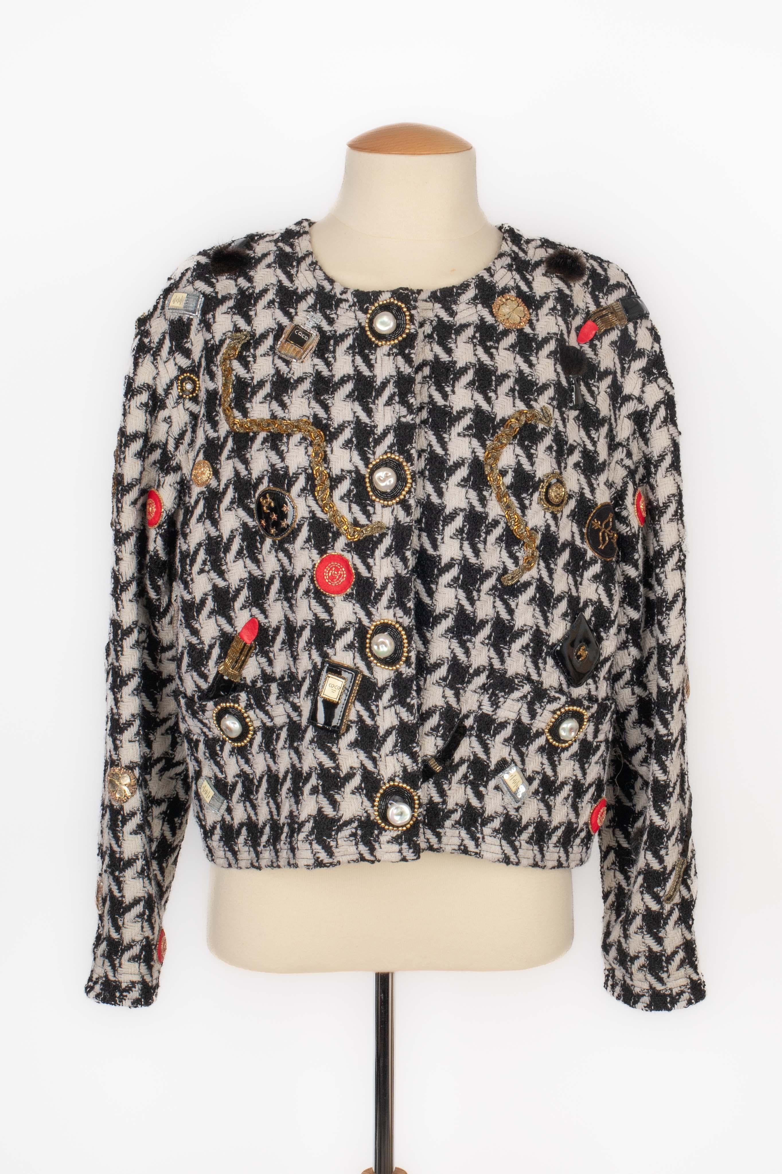 CHANEL - (Made in France) Black and white houndstooth pattern wool jacket decorated with lipstick, perfume, and other leather elements, with patent leather and pearls. Size 40FR indicated. 1987-1988 Fall-Winter Collection under the artistic