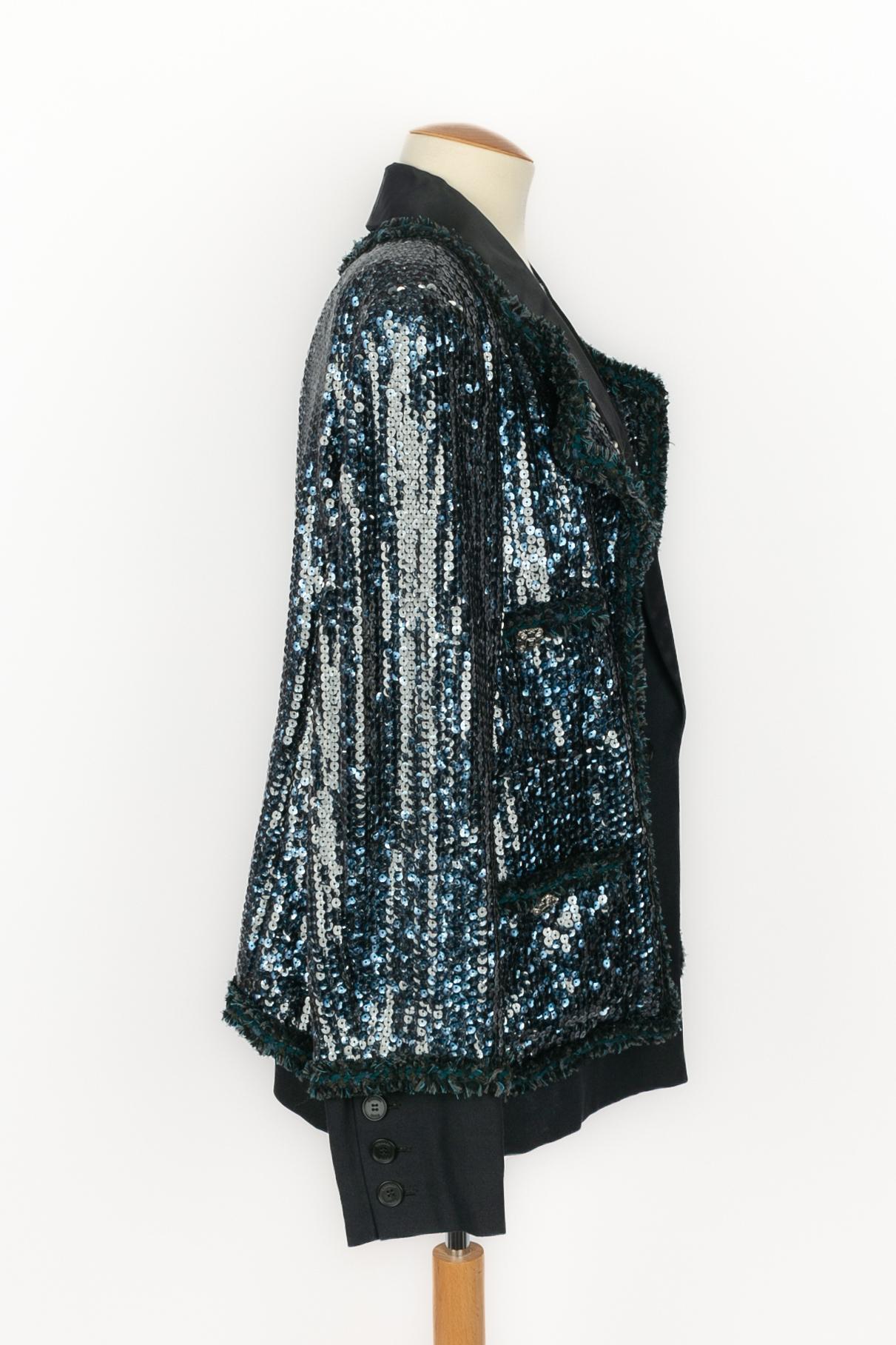 CHANEL - (Made in France) Chaqueta de seda negra con lentejuelas azules. Se indica la talla 48FR. Colección Otoño-Invierno 2011 bajo la dirección artística de Karl Lagerfeld.

Estado:
Muy buen estado

Dimensiones:
Anchura de los hombros: 42 cm -