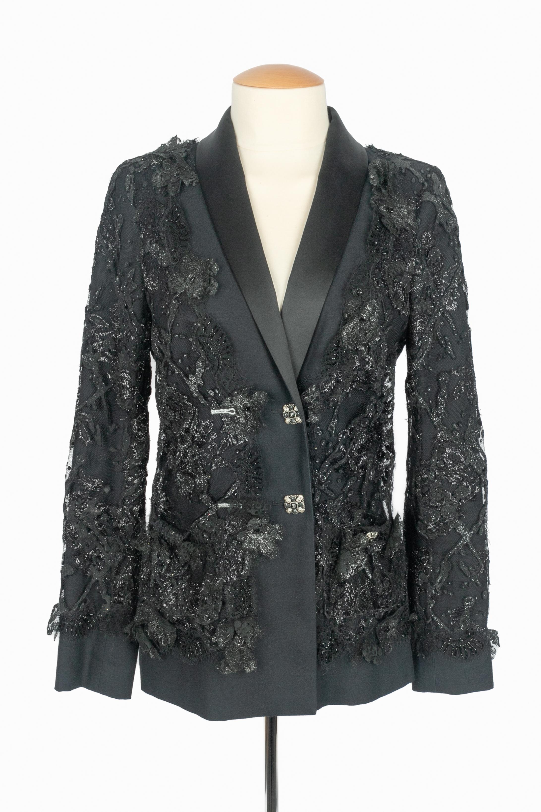 CHANEL - (Fabricado en Francia) Chaqueta negra superpuesta de encaje, con cuello de raso y botones calados de metal plateado decorados con resina y strass. Talla 36FR indicada. Colección Otoño-Invierno 2011 bajo la dirección artística de Karl