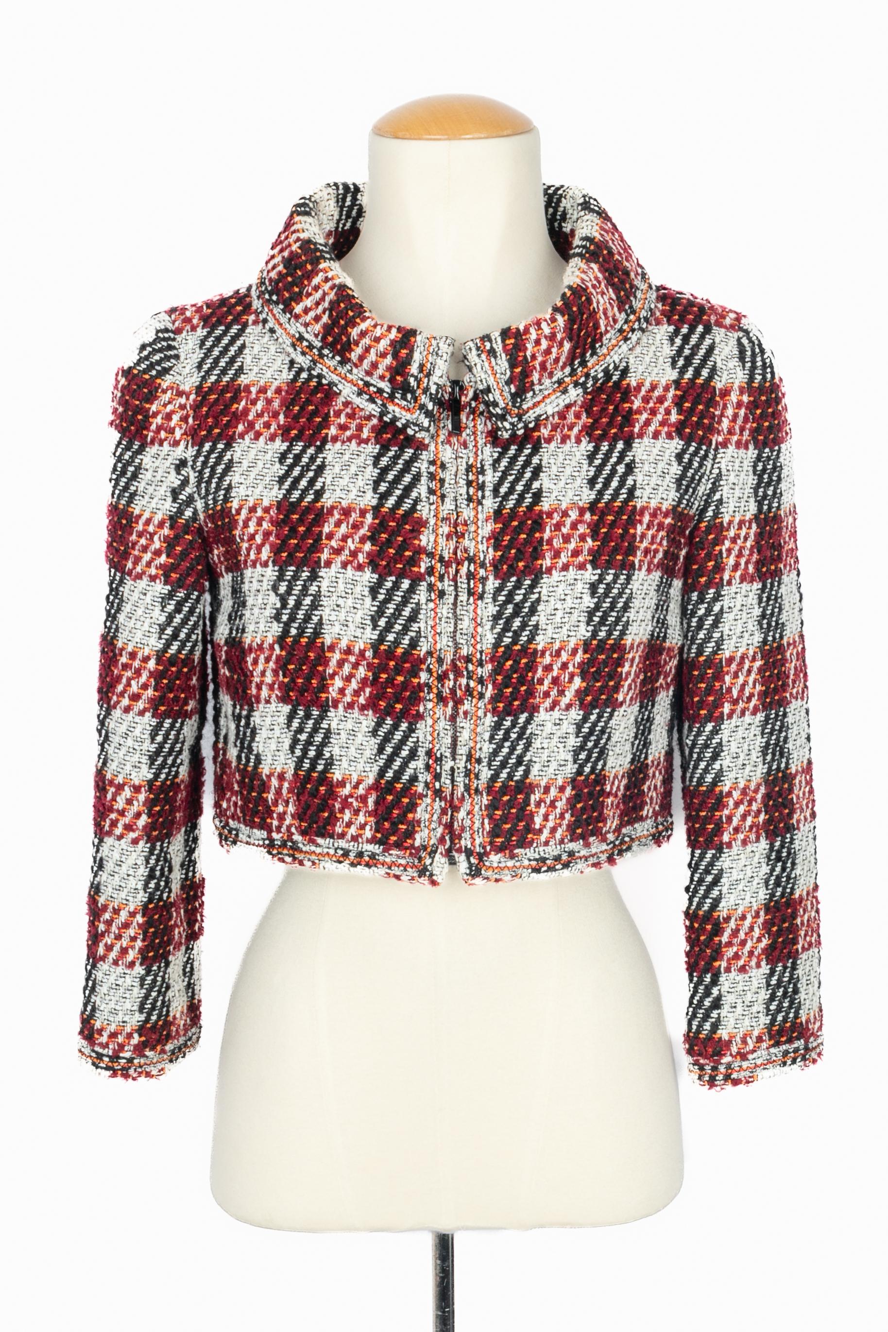 Chanel - (Made in France) Giacca corta in tweed nei toni del rosso, bianco, nero e arancione. Taglia 38FR indicata. Collezione Autunno-Inverno 2016 sotto la direzione artistica di Karl Lagerfeld.

Condizioni:
Ottime condizioni

Dimensioni:
Larghezza