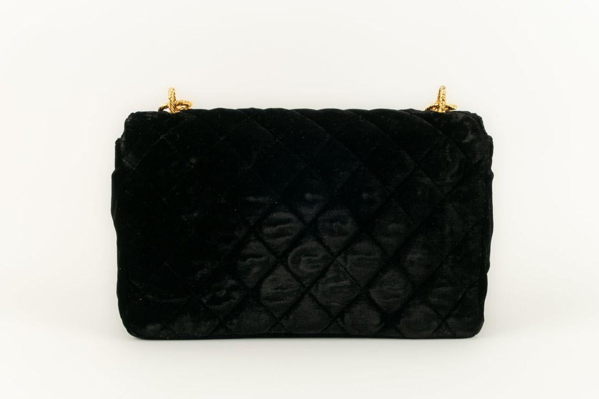 Chanel - (Made in France) Tasche aus schwarzem, gestepptem Samt mit Juwelenverschluss aus goldenem Metall und Glaspaste. Collection'S 1989/1991.

Zusätzliche Informationen: 
Abmessungen: Höhe: 14 cm, Länge: 21 cm, Tiefe: 6 cm, Henkel: 49