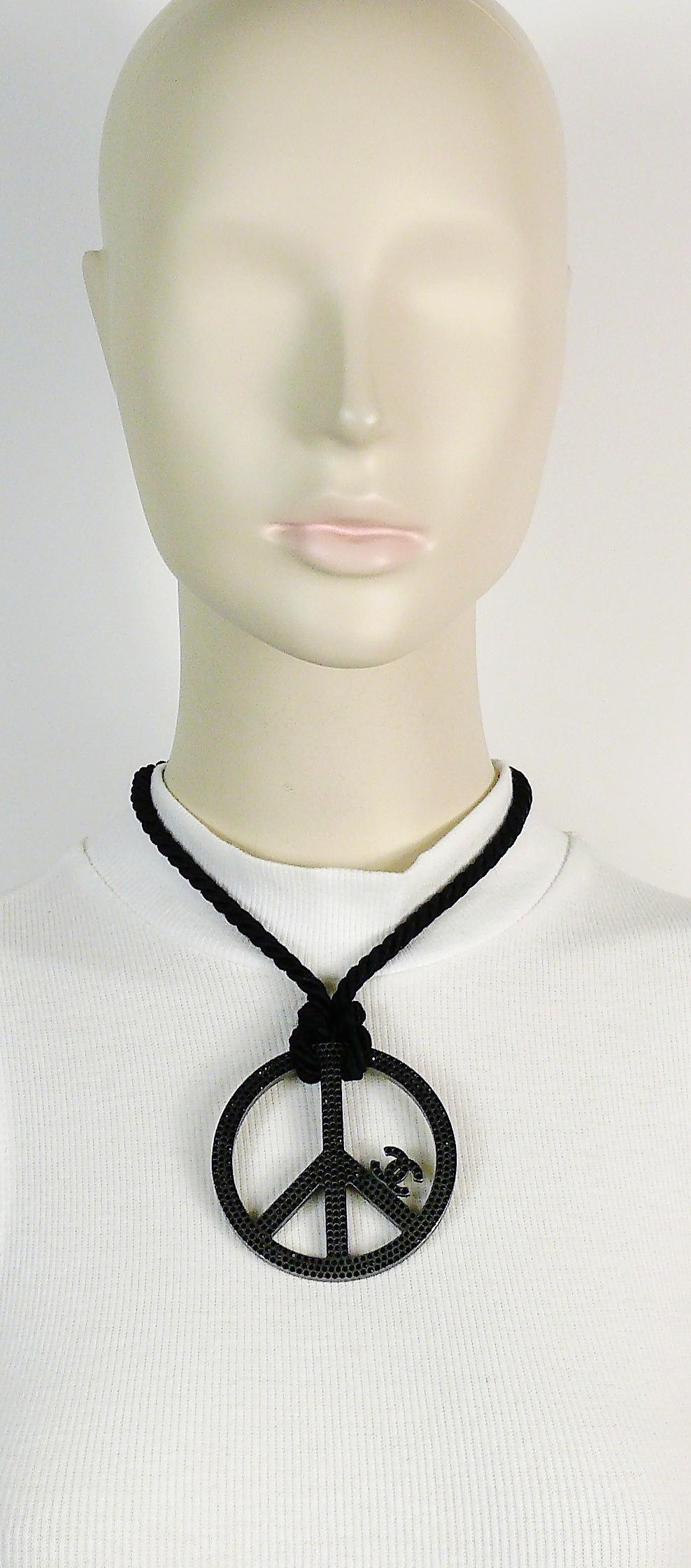 CHANEL black breaded rope necklace featuring a massive brushed ruthenium peace sign embellished with jet black crystals and CC logo.

Spring/Summer 2008 Collection.

Hook closure.

Marked CHANEL 08 P Made in Italy.

Indicative measurements :