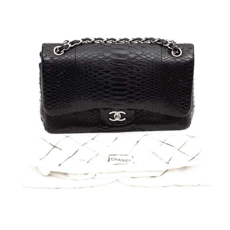 Beautiful CHANEL piece Jumbo model with double flap in black python. The jewelry is made of palladium silver metal and the chain is interlaced in python. It is lined with smooth black leather. It has a large storage space with three pockets, one of
