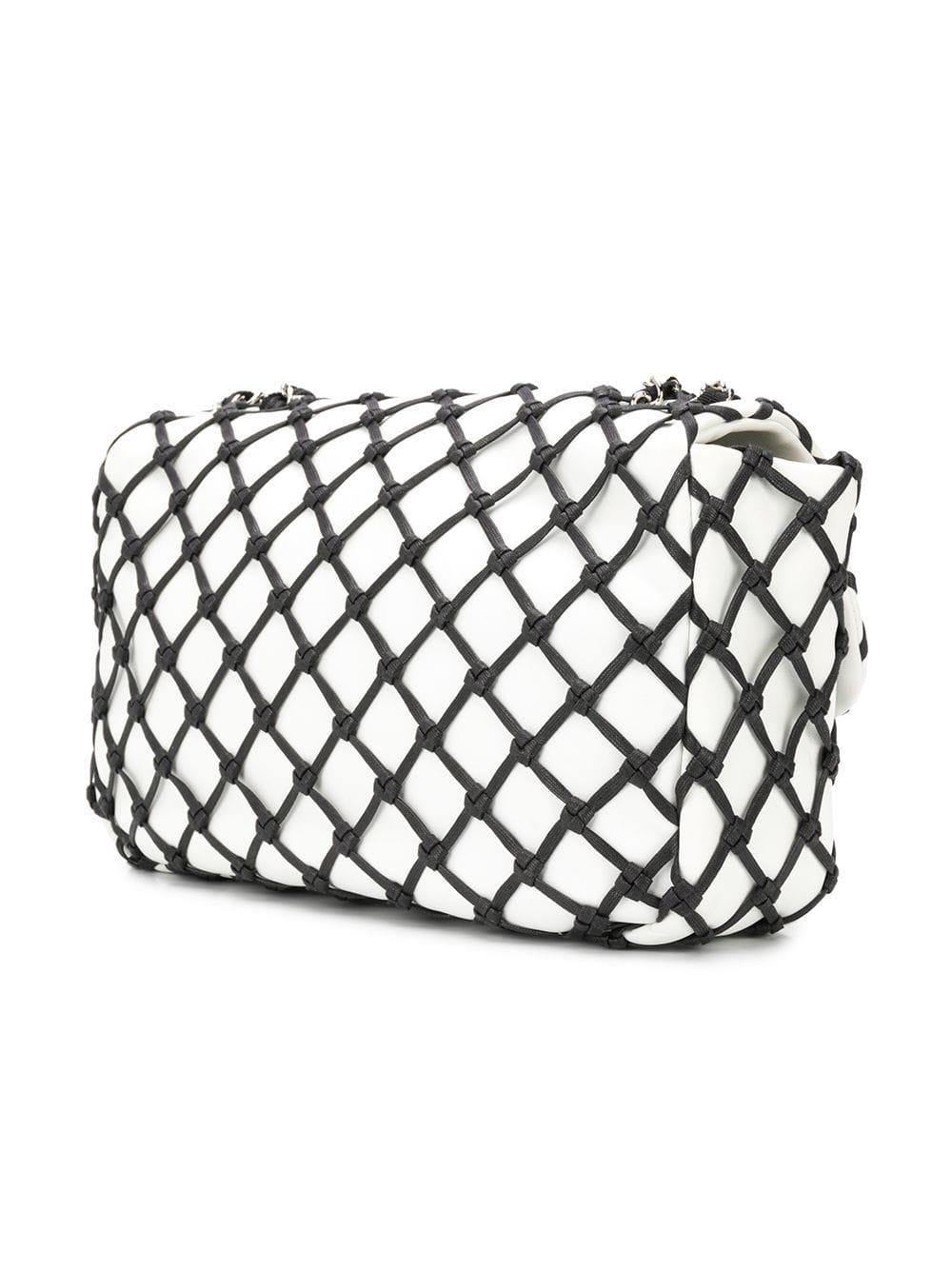 For a dazzling twist on the classic Chanel flap bag, look no further. This edgy Jumbo Canebiers piece playfully mimics the house's iconic diamond quilted fabrications with its black mesh effect nylon netting. Featuring the brands signature details,