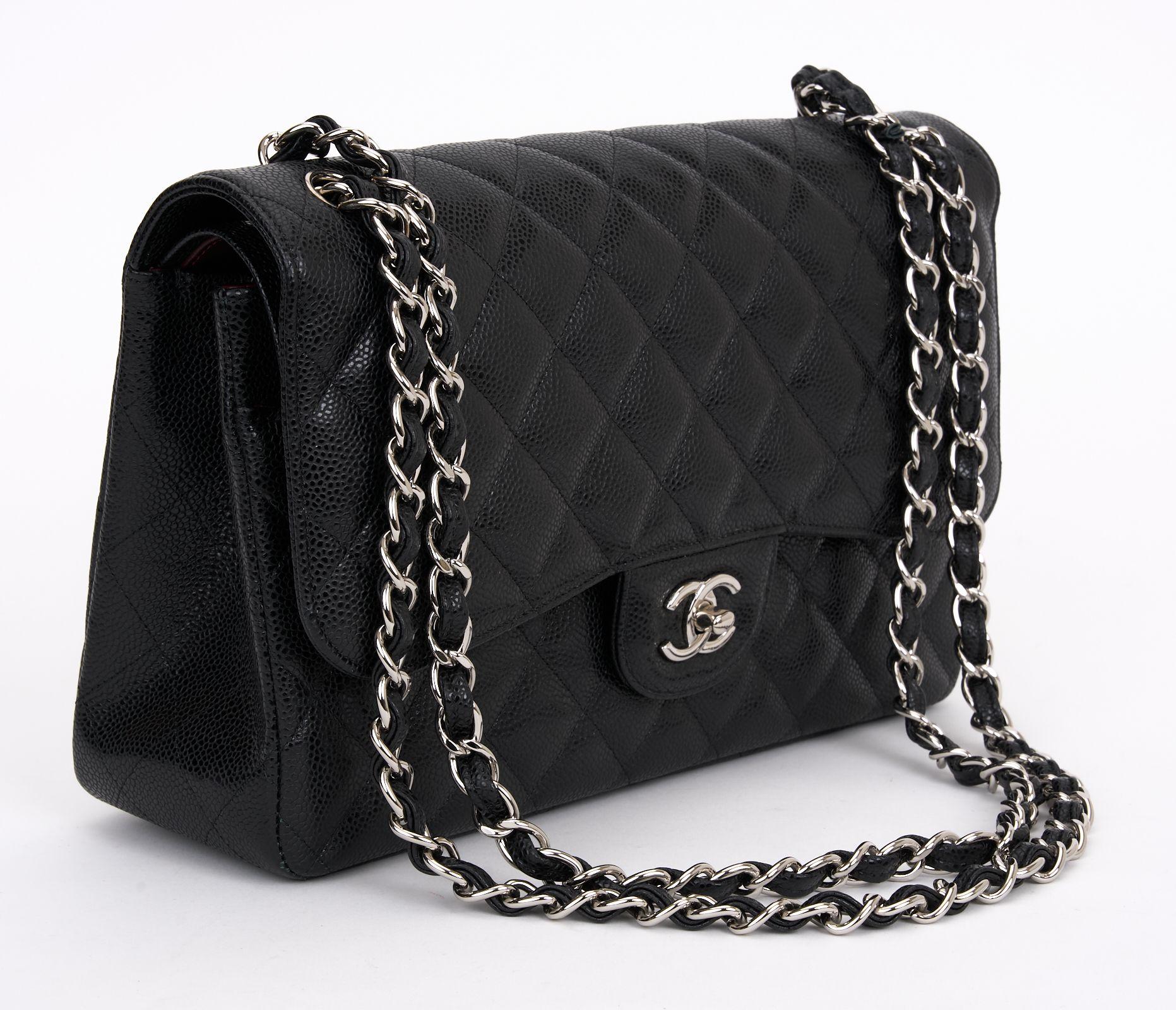 This Jumbo Classic Double Flap bag is in black caviar leather with silver-tone hardware. It features a front flap with the signature CC turn-lock closure, a half-moon back pocket, and an adjustable interwoven gold-tone chain link and black leather