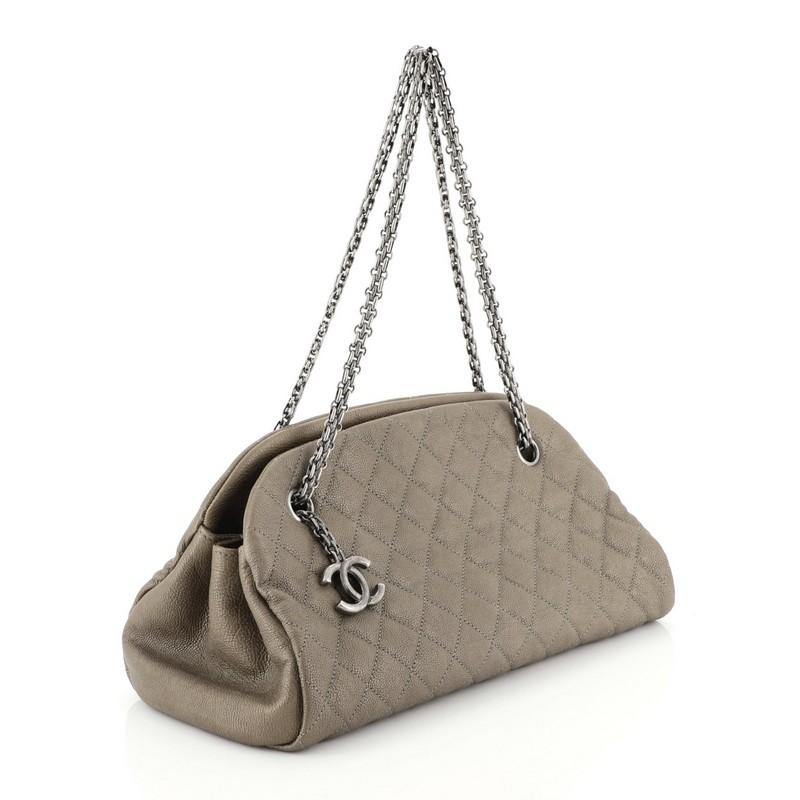 This Chanel Just Mademoiselle Bag Quilted Caviar Medium, crafted from neutral quilted caviar leather, features woven-in leather chain straps, protective base studs, and aged silver-tone hardware. It opens to a red fabric interior with two side