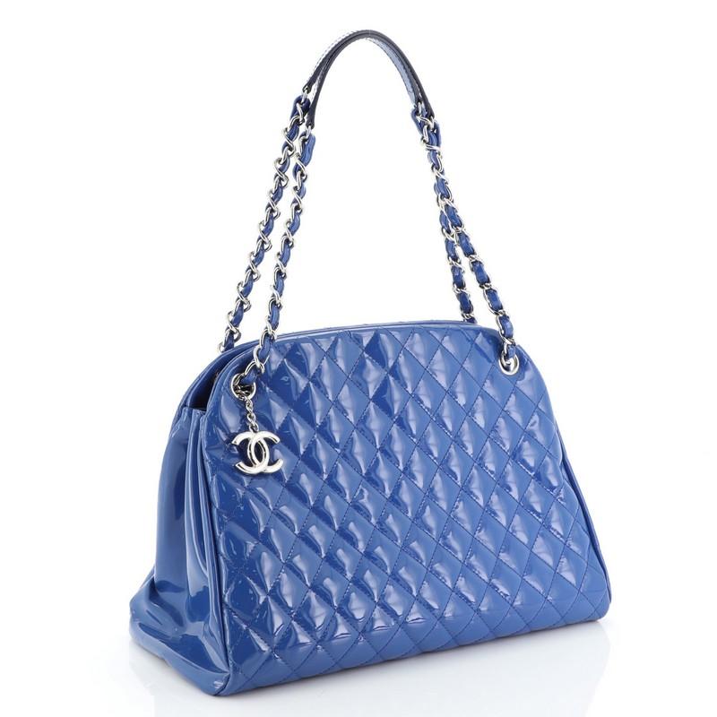 This Chanel Just Mademoiselle Handbag Quilted Patent Large, crafted from blue quilted patent leather, features dual woven-in leather chain straps, protective base studs, and silver-tone hardware. Its magnetic snap closure opens to a blue fabric