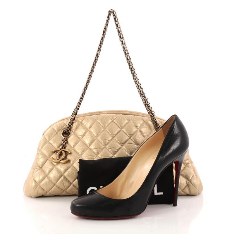 This authentic Chanel Just Mademoiselle Handbag Quilted Aged Calfskin Medium showcases a sleek style that complements any look. Crafted from beautiful gold metallic aged calfskin leather in Chanel's iconic diamond quilting pattern, this shell-like