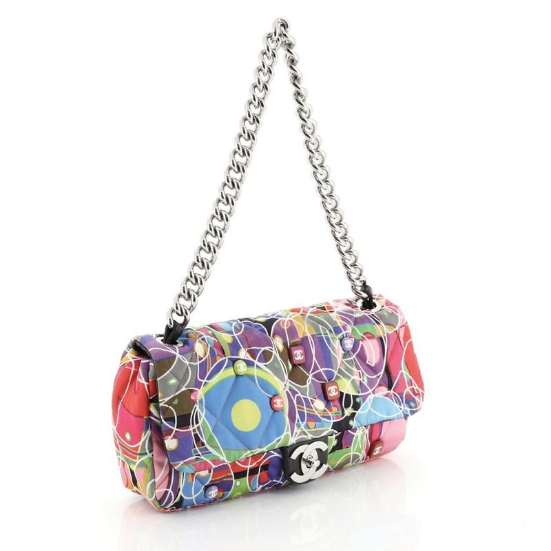 This Chanel Kaleidoscope Chain Flap Bag Quilted Printed Satin Medium, crafted from multicolor kaleidoscope geometric print quilted fabric, features chunky chain-link shoulder strap, adorable Chanel buttons and gunmetal-tone hardware. Its CC