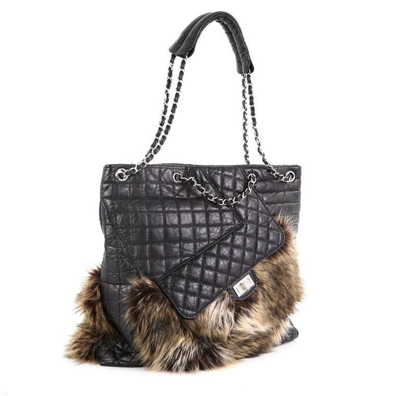 This Chanel Karl's Fantasy Cabas Tote Fur and Quilted Leather, crafted from black quilted leather and fur, features woven-in leather chain straps, exterior front pocket with mademoiselle turn-lock closure, exterior back slip pocket, and silver-tone
