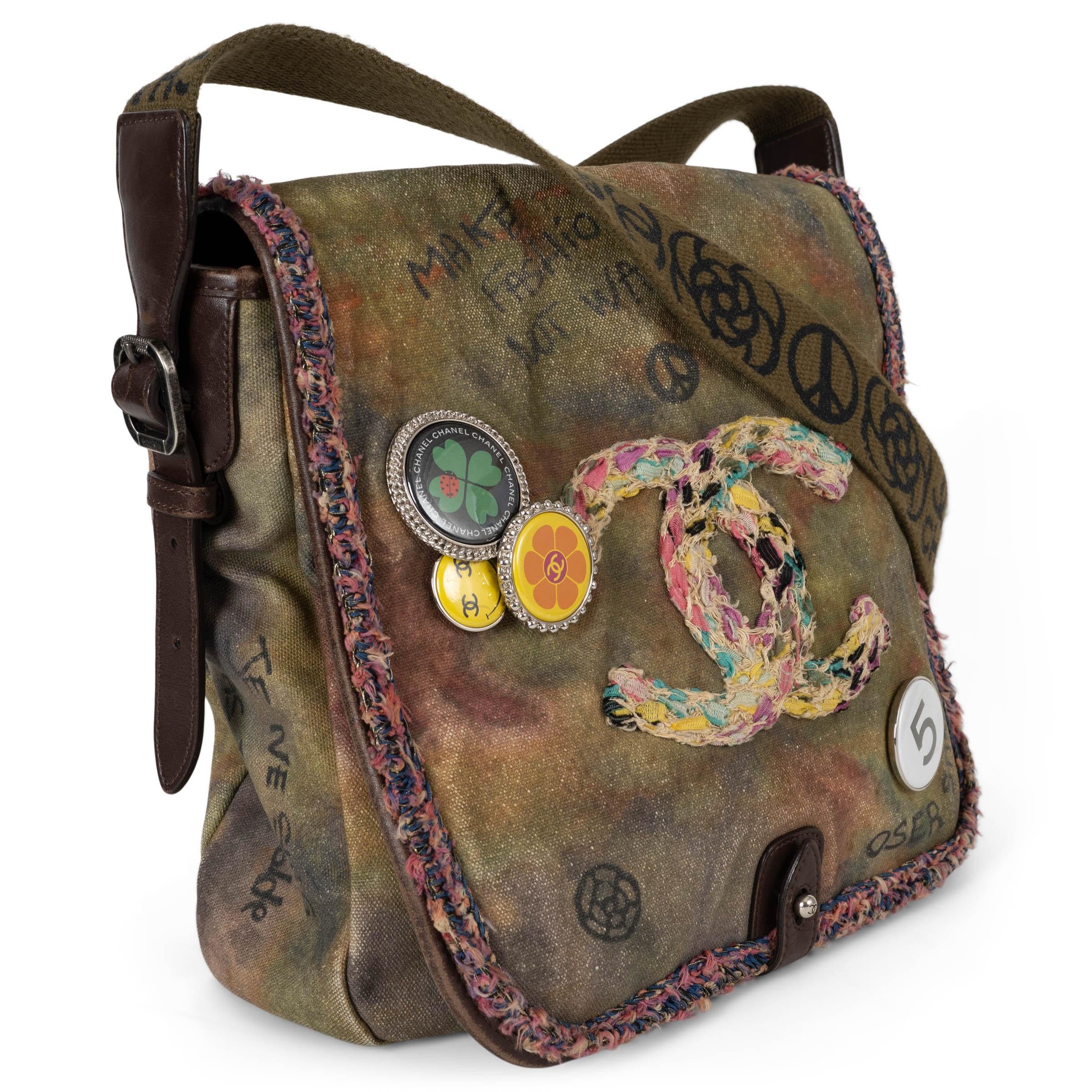 This 100% authentic Chanel On the Pavements small messenger bag is a rare runway-inspired piece crafted in khaki and multi-color washed toile canvas, accented with chocolate calfskin details. The front flap is boldly embroidered with a multi-color