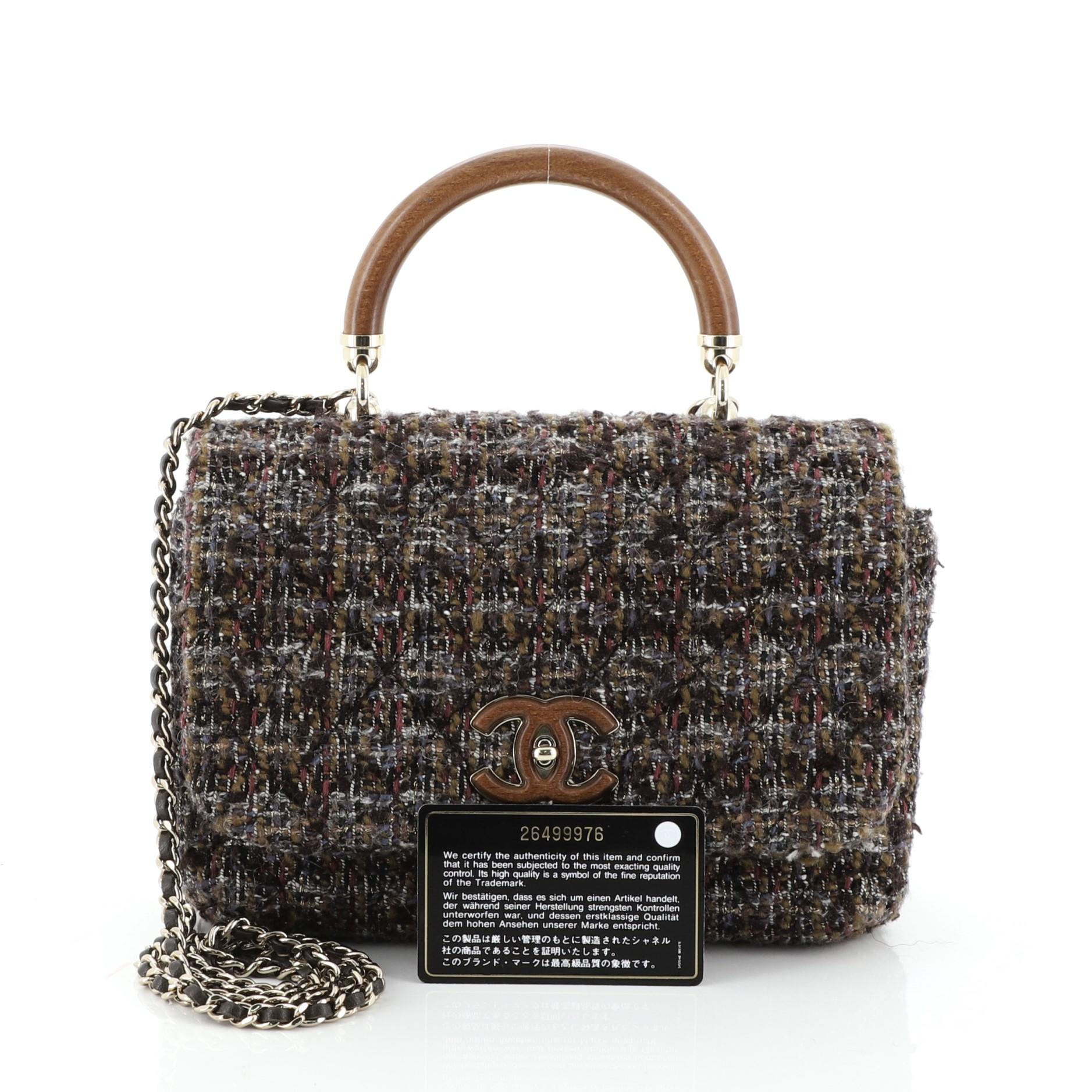 This Chanel Knock on Wood Top Handle Bag Quilted Tweed Mini, crafted in brown quilted tweed, features a wood top handle, woven-in leather chain strap and gold-tone hardware. Its turn-lock closure opens to a brown fabric interior. Hologram sticker