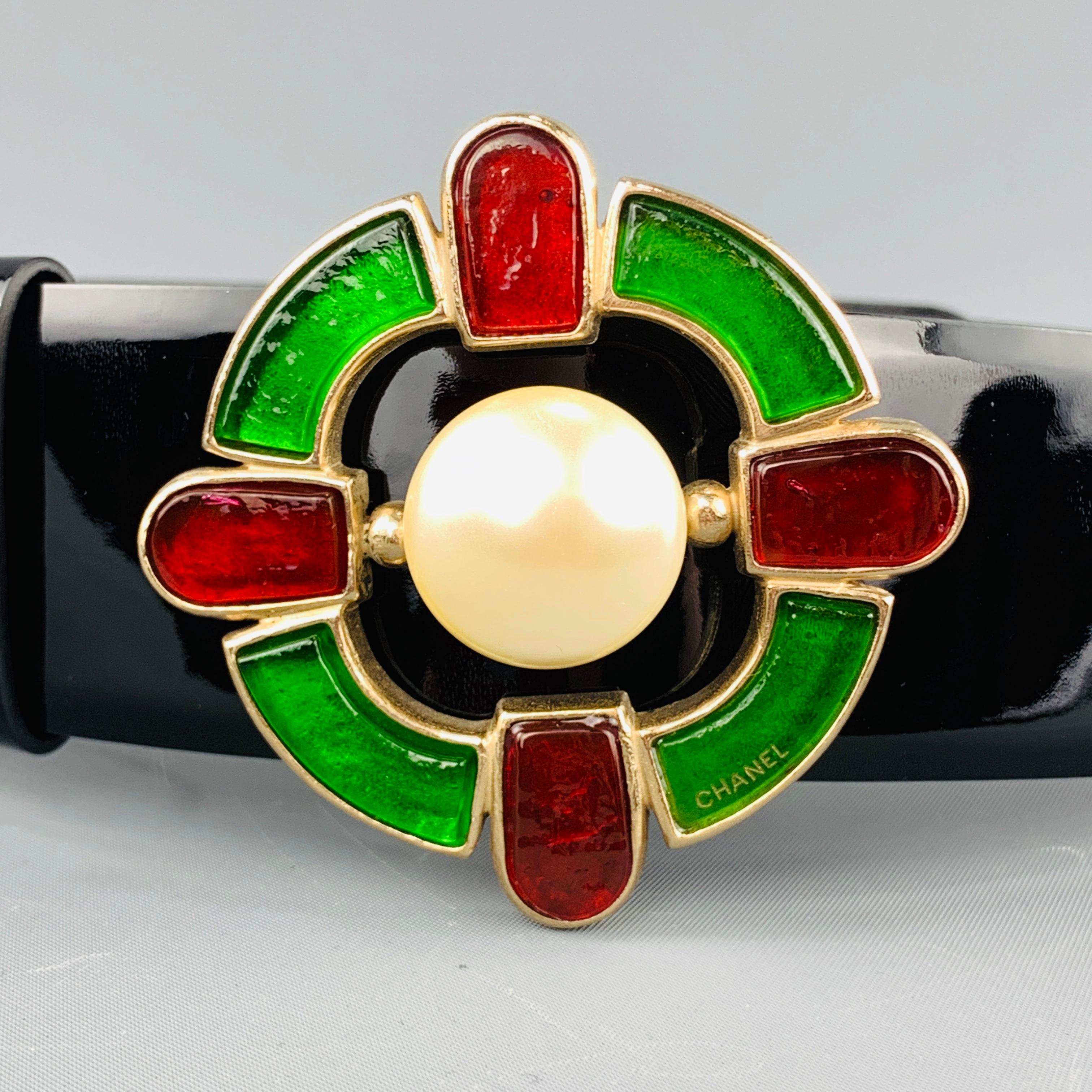 CHANEL Fall Winter 2007 Collection belt features a black glossy patent leather thick strap with a light gold tone metal Gripoix Celtic cross buckle detailed with red and green gem and faux pearl center. Made in Italy.
 
Excellent Pre-Owned