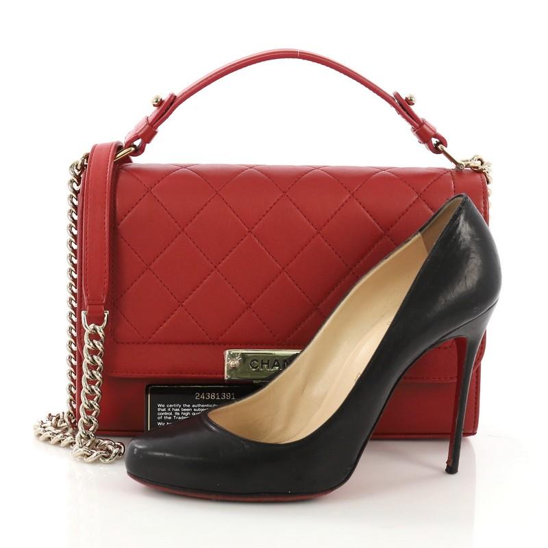 This Chanel Label Click Flap Bag Quilted Calfskin Medium, crafted from red quilted calfskin, features a leather top handle, chain link strap with leather pad, and gold-tone hardware. Its push-lock closure opens to a red fabric interior with side zip