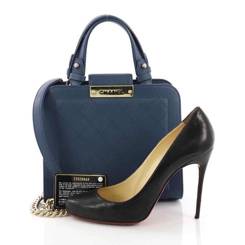 This Chanel Label Click Shopping Tote Quilted Calfskin Small, crafted in blue quilted calfskin, features dual flat leather handles, chunky chain link strap with leather pad, and gold-tone hardware. Its magnetic snap closure opens to a beige fabric