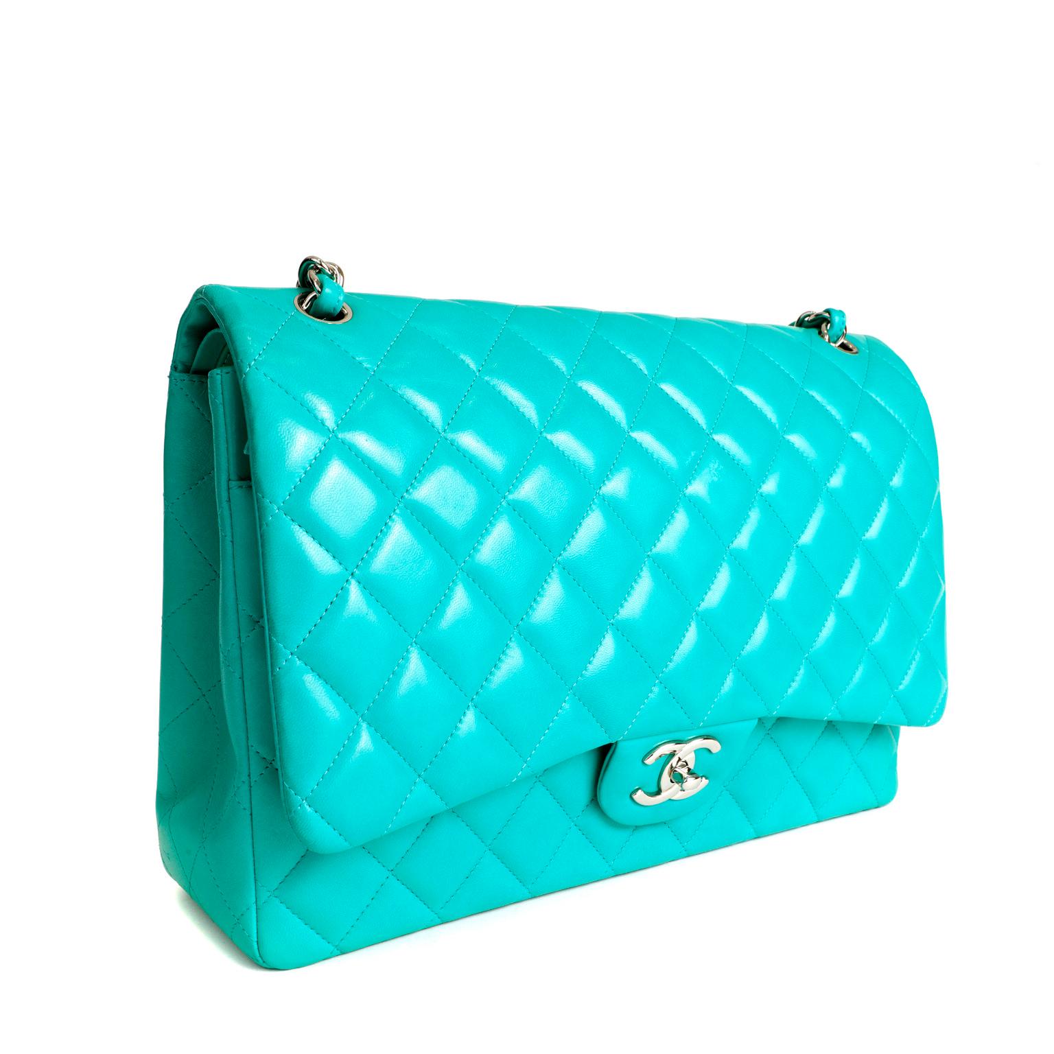 This authentic Chanel Lagoon Lambskin Maxi Classic Flap is in pristine condition. The highly coveted iconic silhouette is a must have for any collection.
Lagoon sea green lambskin is quilted in signature Chanel diamond pattern. Silver tone