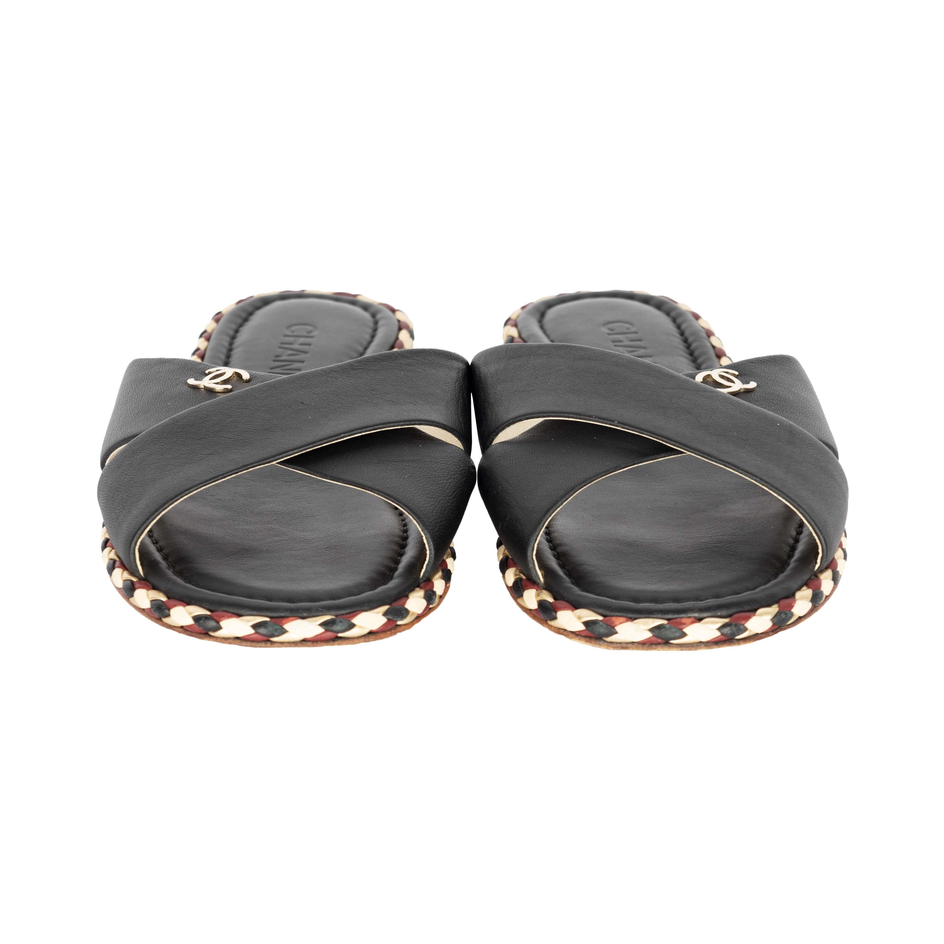 Add a touch of elegance to your ensemble with these exquisitely crafted Chanel Slides. Made with black leather, the crisscross straps are accented with the CC logo while the outsole is embellished with a multicolor braid. The branded flair is