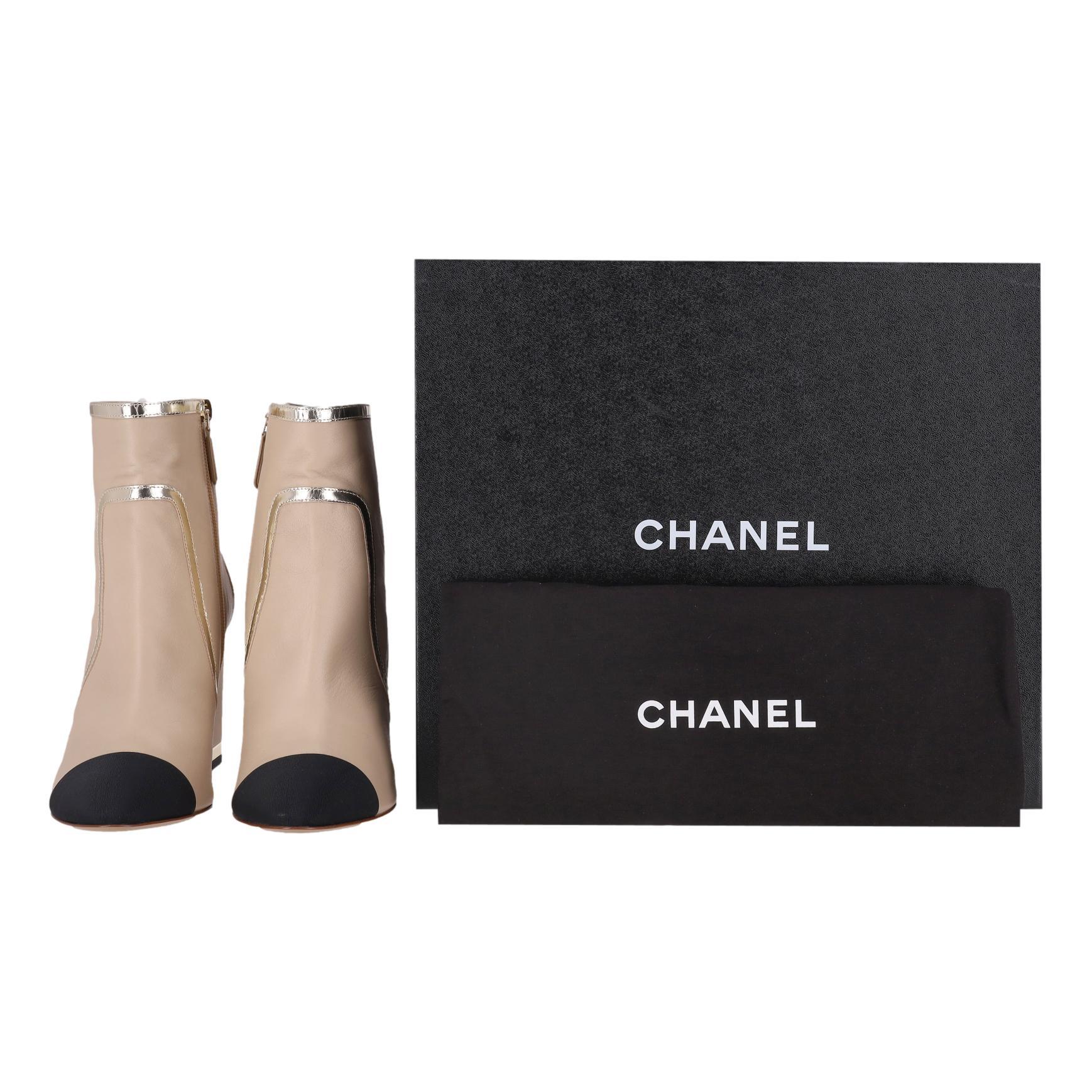 Stivaletti Chanel in pelle di agnello con finiture in grosgrain e logo 'CC' sul tallone

Stivaletti beige realizzati in morbida pelle e impreziositi da dettagli in vernice argento.

Caratterizzate da una punta a mandorla rifinita in gros grain nero