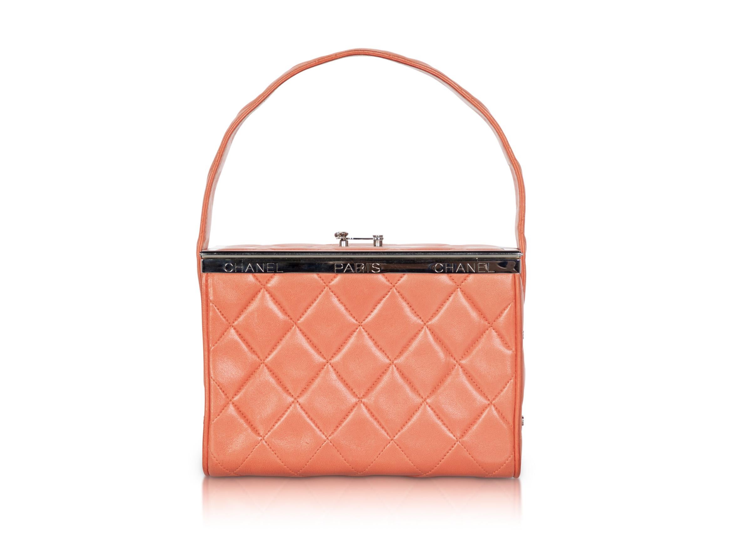 A fabulous and rare vintage Chanel box bag in a melon orange color done  in luxurious lambskin leather.
Features: A single compartment with a side pocket . Double frame top opening with a hook closure accented with a silver 