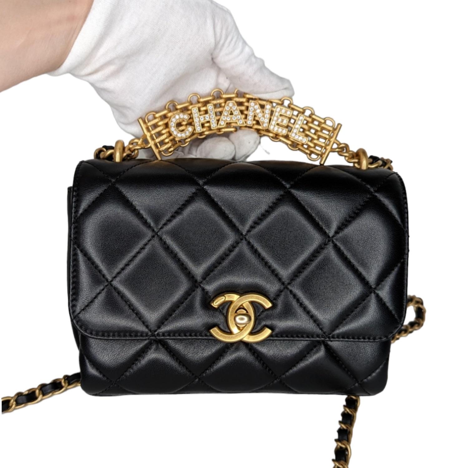From the Spring/Summer 2022 Collection by Virginie Viard. This shoulder bag is crafted of lambskin leather in black. The bag features a gold reissue top handle with a crystal encrusted Chanel logo, a leather threaded aged gold chain shoulder strap,