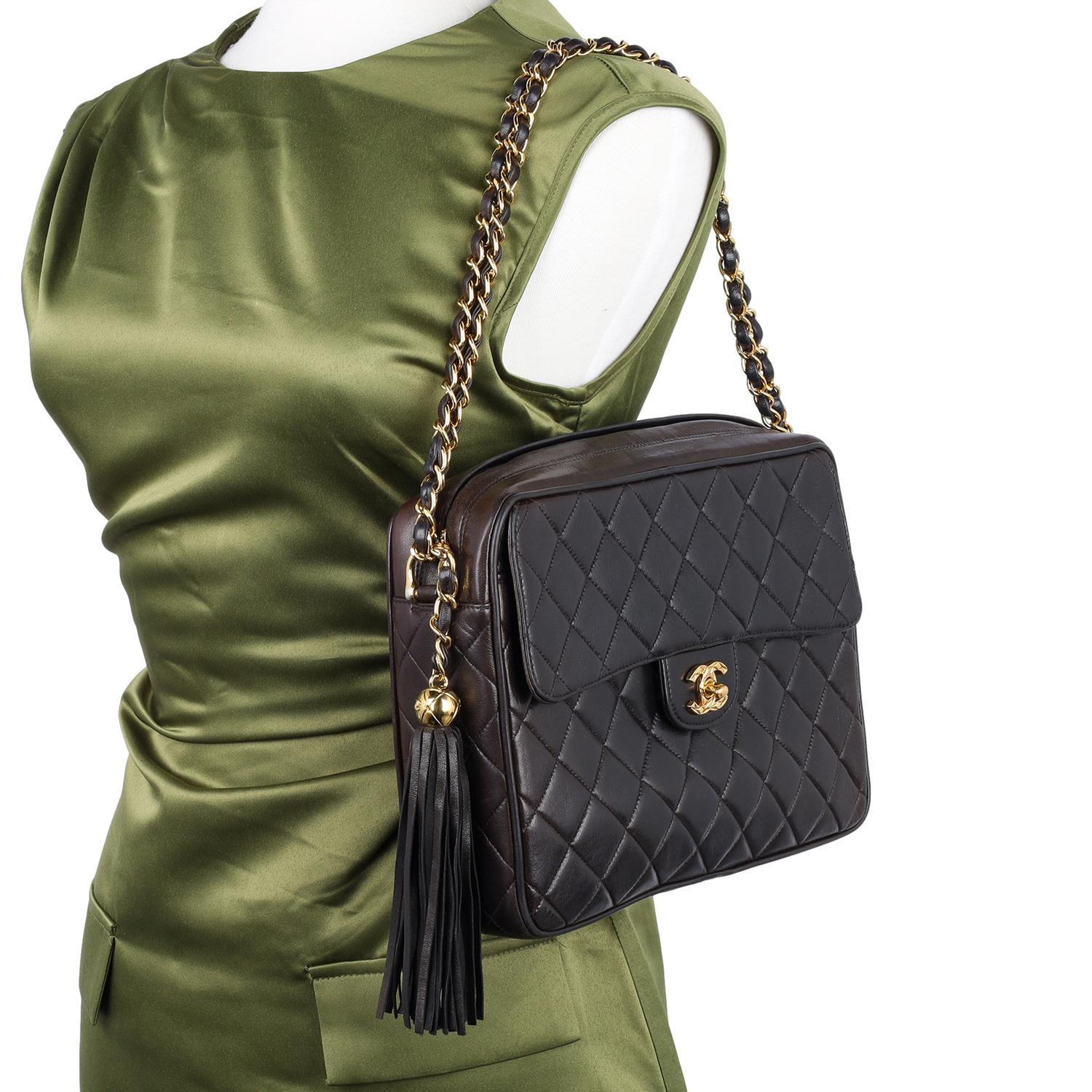 Authentic Chanel leather quilted flap camera shoulder bag. This bag is in amazing condition! Features black quilted lambskin leather with 24kt gold plated hardware, a  woven chain strap, and a zipper top closure with a tassel pull, front turn-lock