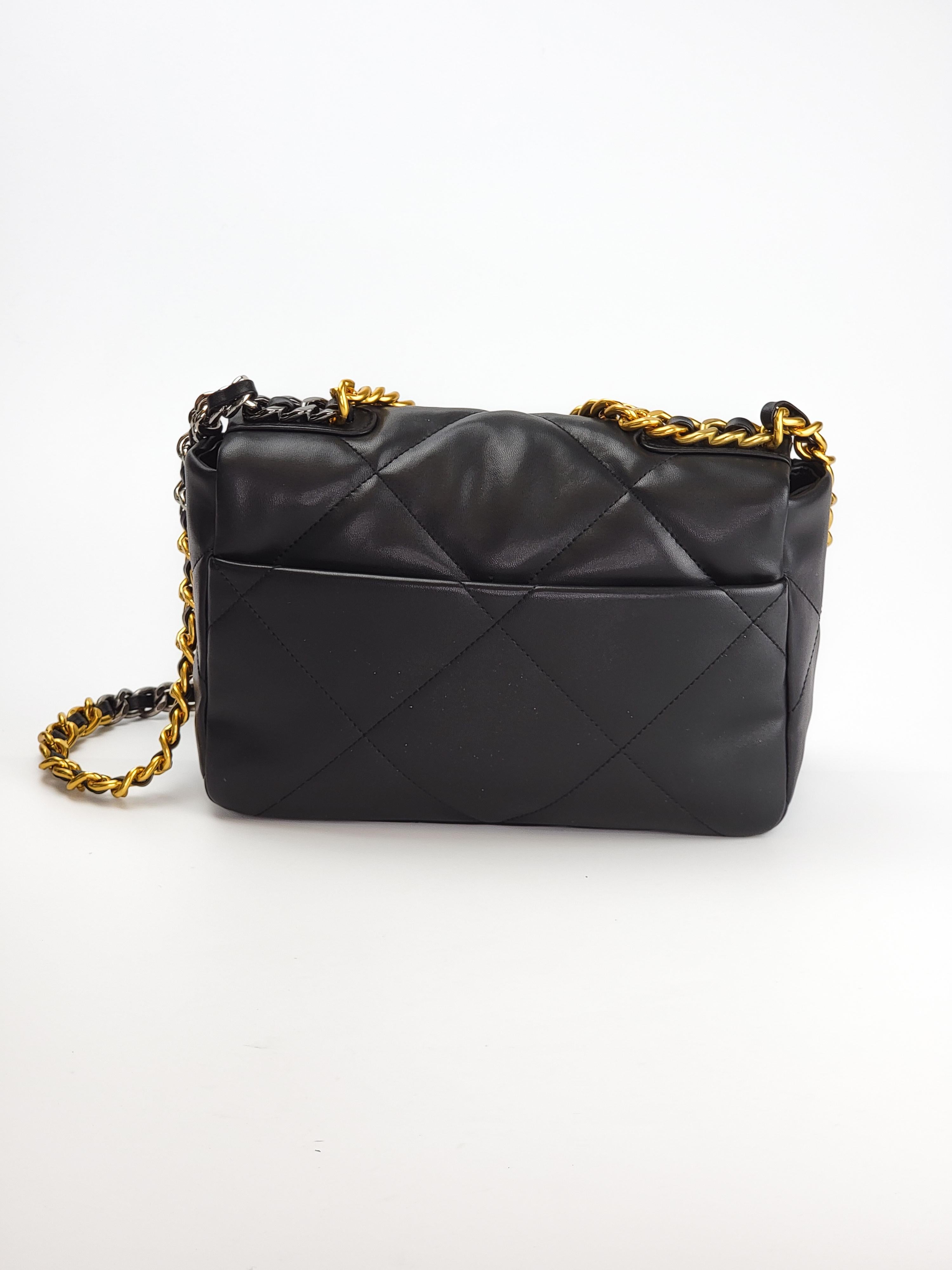 This Chanel handbag is made with supple lambskin quilted leather in black.  The bag features signature diamond stitching, gold and sliver tone hardware, a front flap with the signature interlocking CC turn lock closure, a metallic chain strap