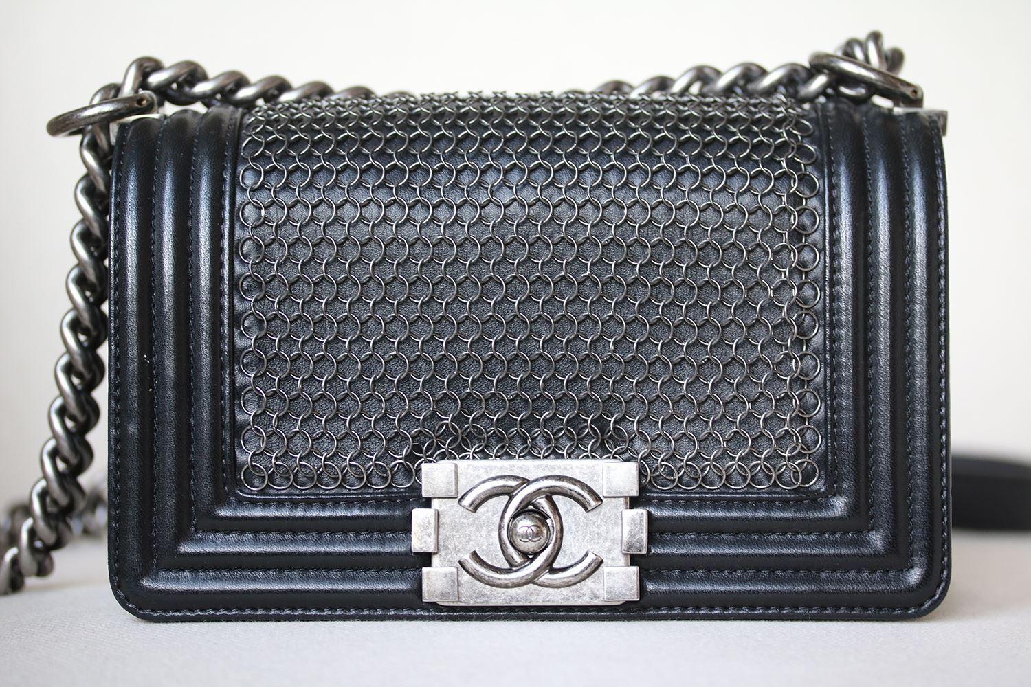 Chanel Lambskin Quilted Small Chain Mail Boy Flap Black. This chic baguette is crafted of small thin chains on the lambskin leather with a structured rectangular silhouette. The bag features an aged silver chain link shoulder strap with a leather