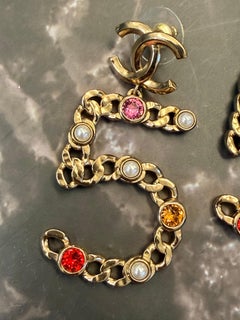 GRANDES BOUCLES D'OREILLES CHANEL À 5 CLOUS EN MÉTAL DORÉ, ornées de perles et de pierres