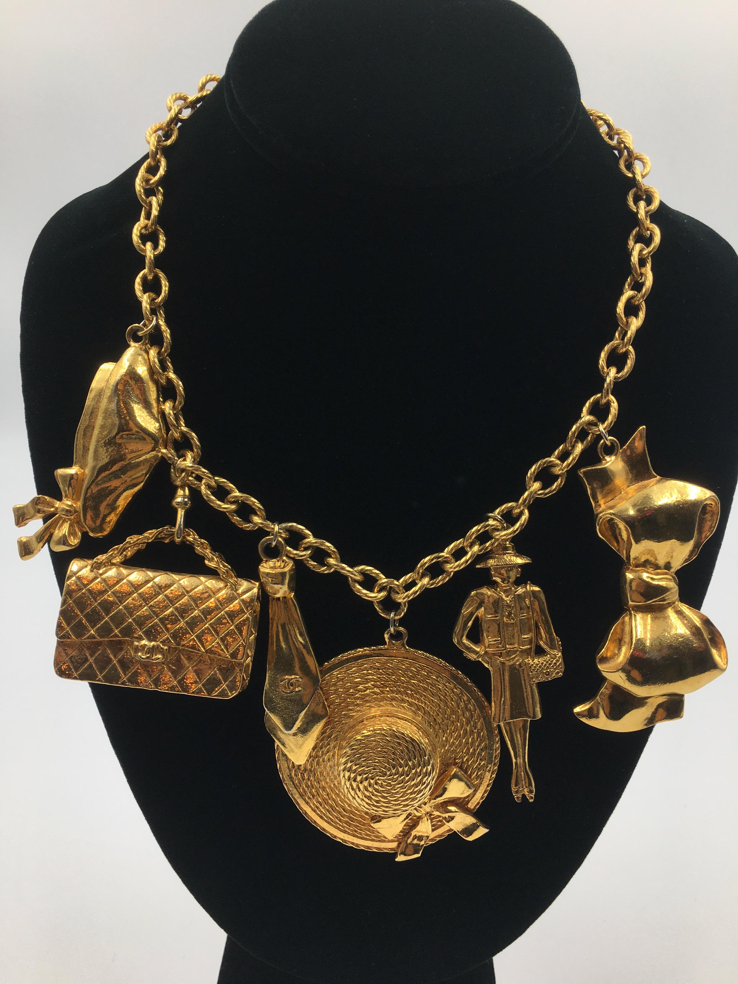 Chanel 6 Charm gold tone necklace with the most iconic symbols of Chanel. Charms include Coco Chanel barrette, Classic Chanel quilted bag, Coco Chanel neck tie, a large brim hat with bow, Coco Chanel charm and the big Chanel bow. In good vintage