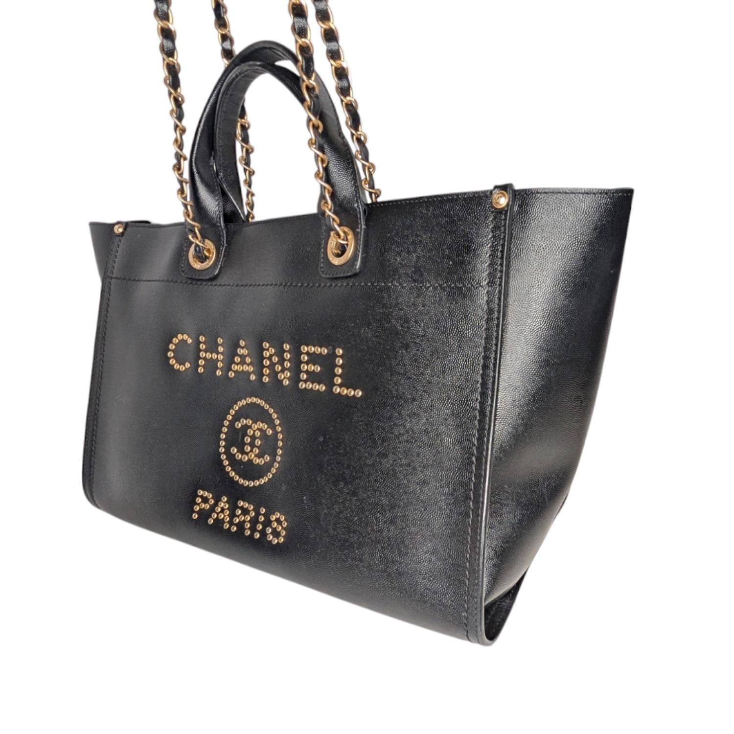 This fun and fabulous bag makes the perfect everyday or travel tote! The Chanel Black Caviar Leather Studded Large Deauville Tote Bag features gorgeous caviar grained leather with a studded Chanel logo at the center. The bag comes with short leather