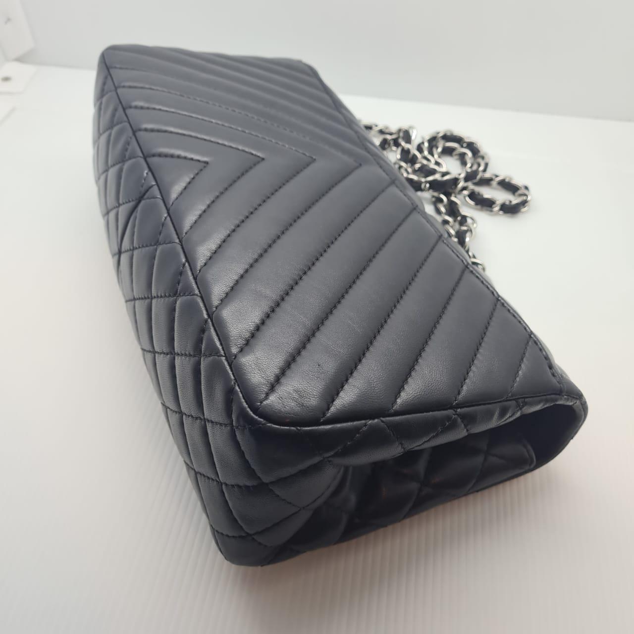 Beautiful large lambskin chevron flap bag in black. Minimal wear, with light scuffing on the leather surface and flap lining. Overall normal wear throughout, nothing major. Series #17. Comes with card and dust bag.
